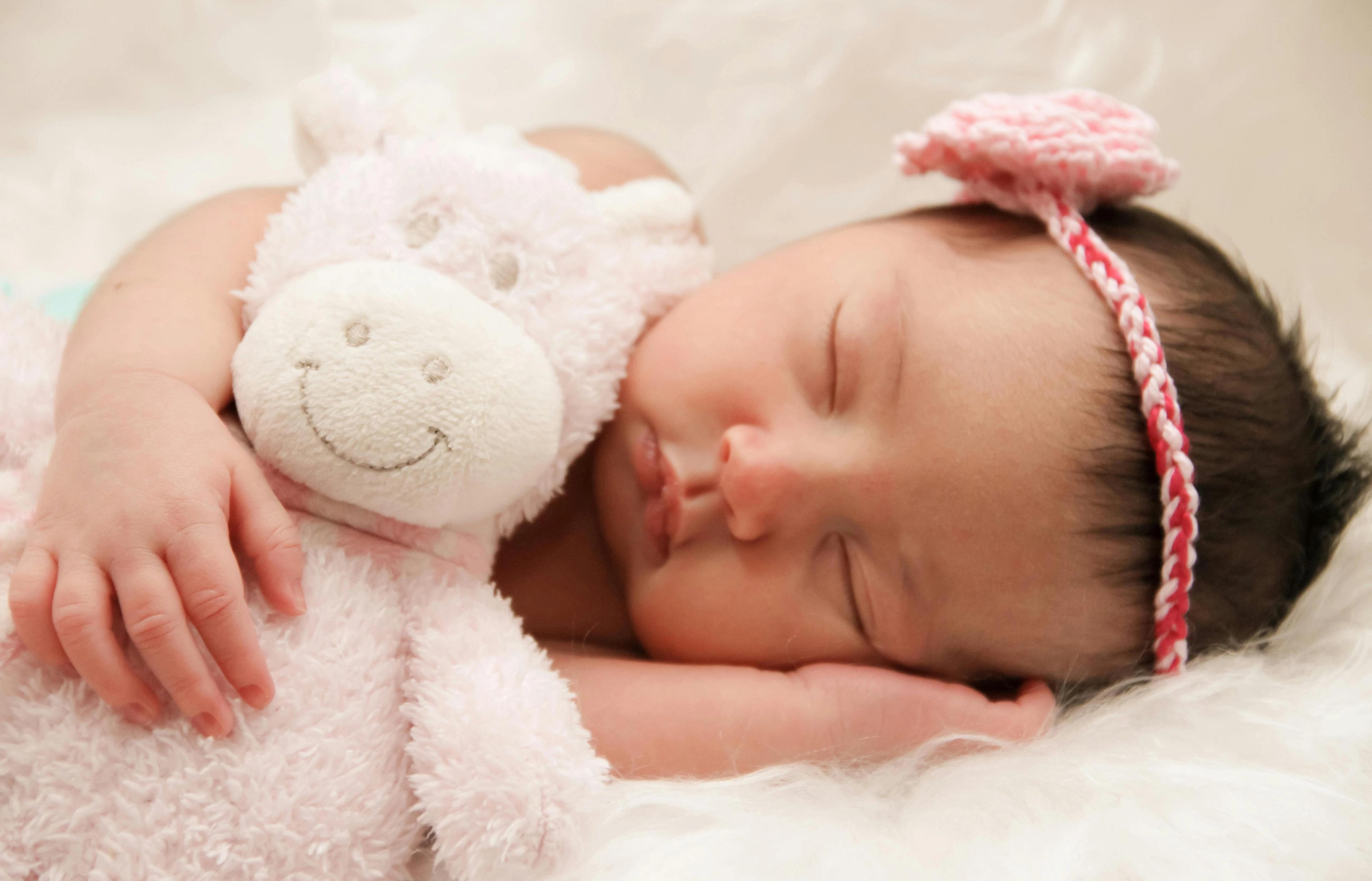 søt baby som sover med bamse