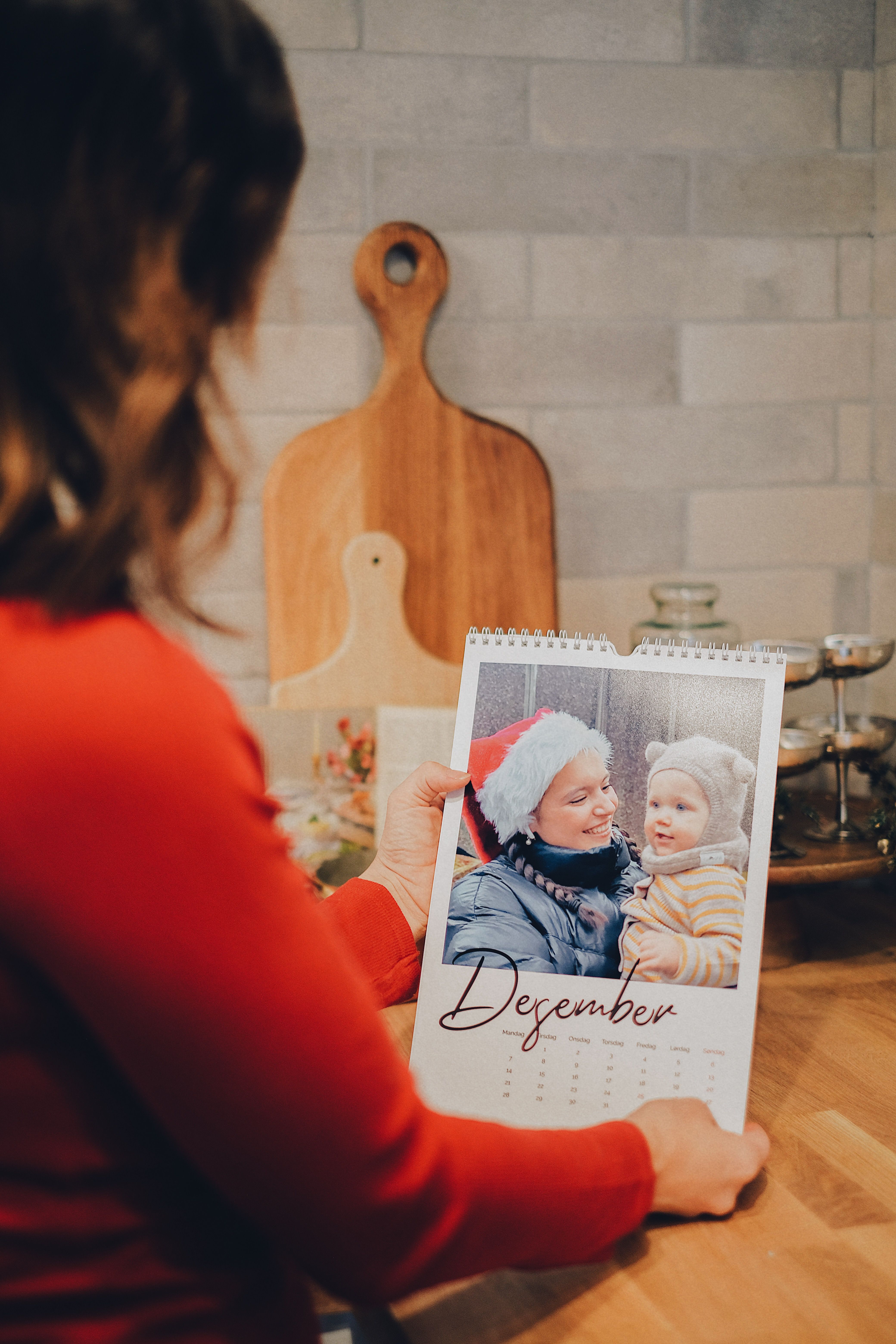 Dame som ser på en fotokalender med et stort bilde og teksten desember