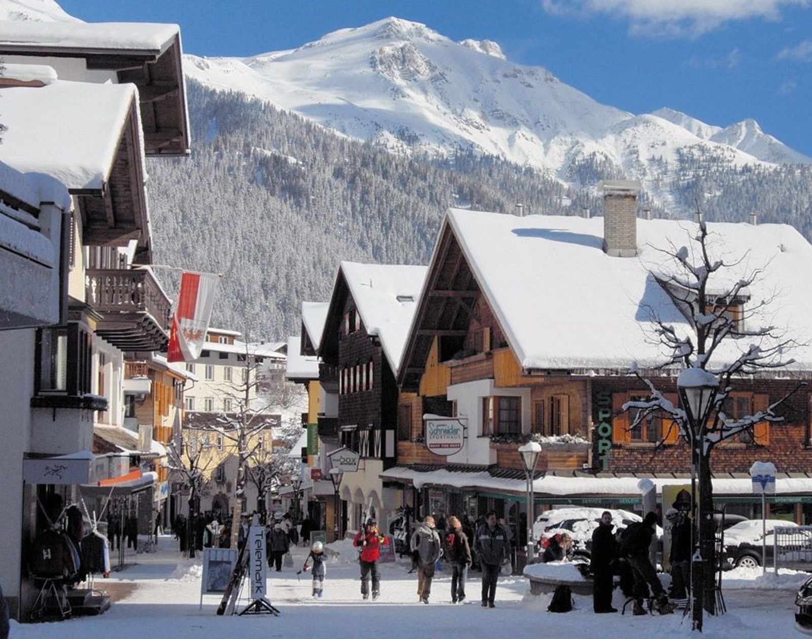 View of the main St Anton village in winter with classic chalet architecture and pedestrians walking down the street