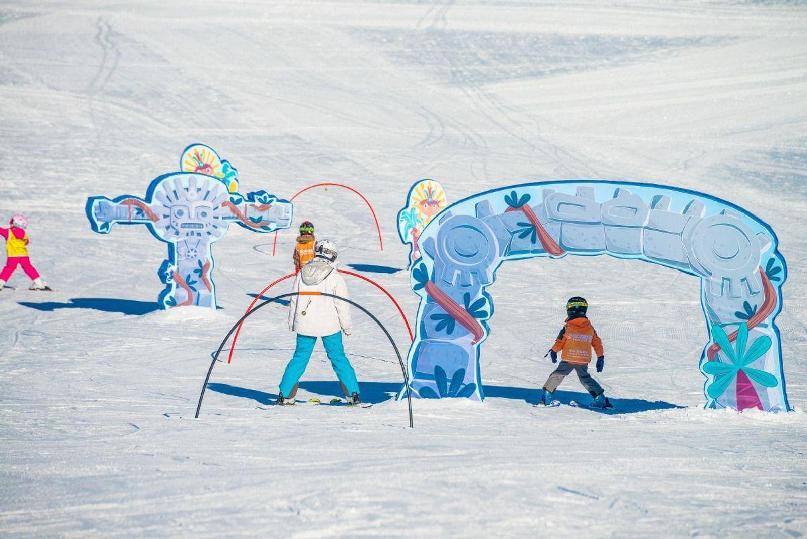 Family skiing on a nursery slope in Val d'Isere