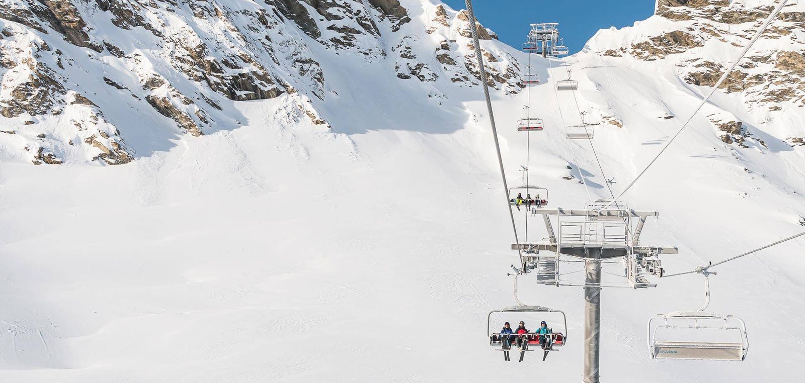 Val d'Isere chairlift with skiers heading up the mountain