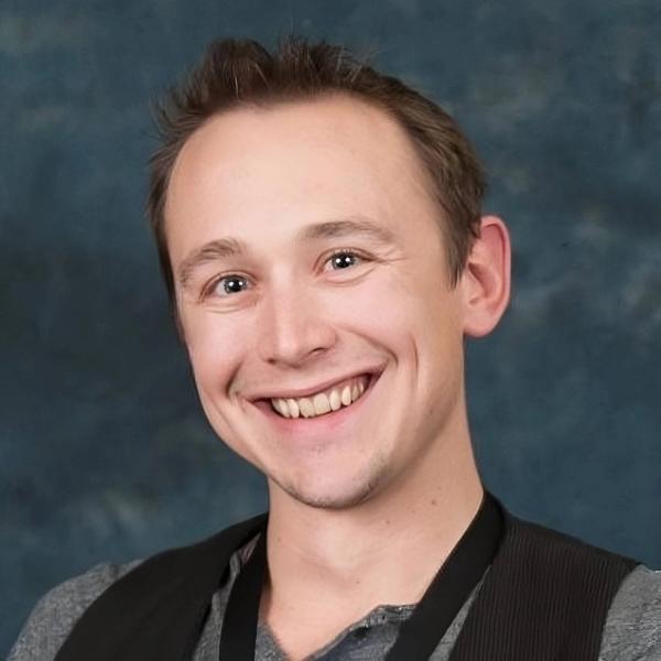 Headshot of Ryan Stromquist against a blue backdrop