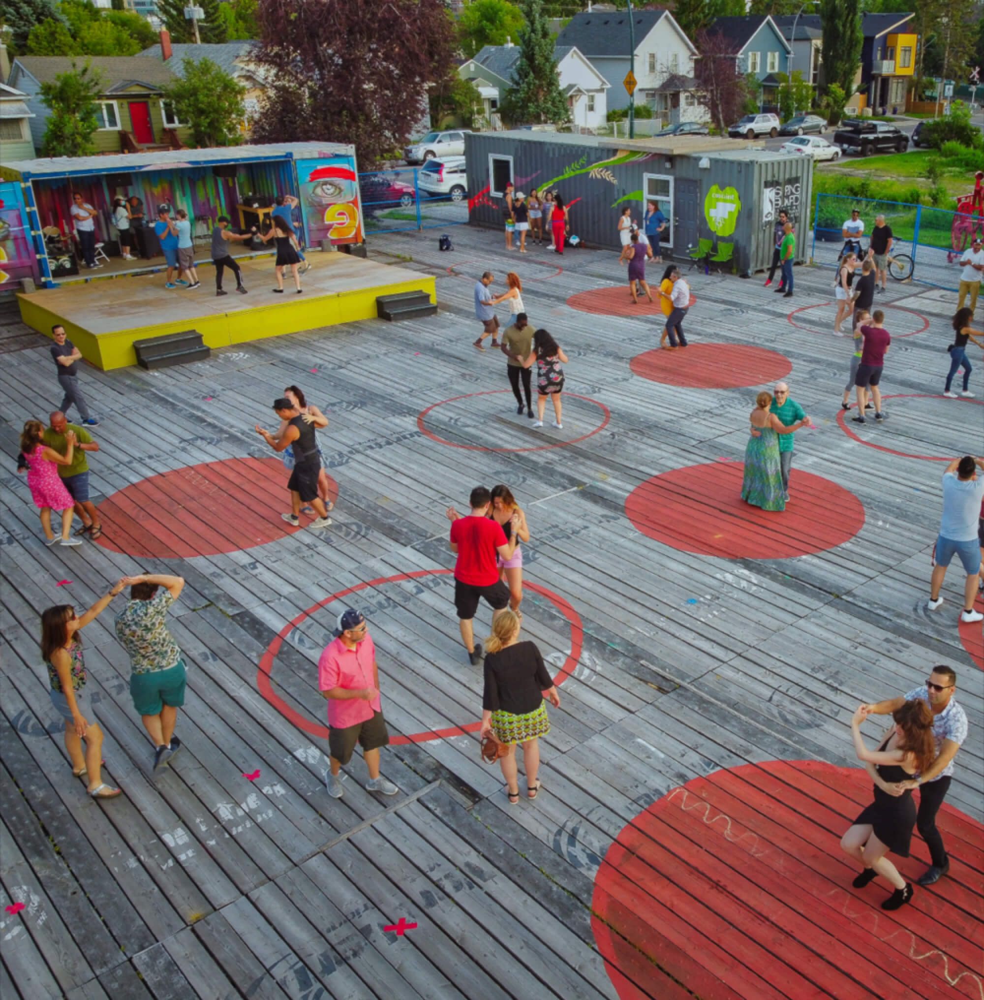 People dance in pairs on brightly-painted circles at an event