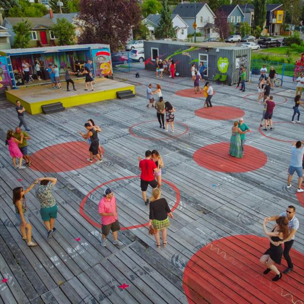 People dance in pairs on brightly-painted circles at an event