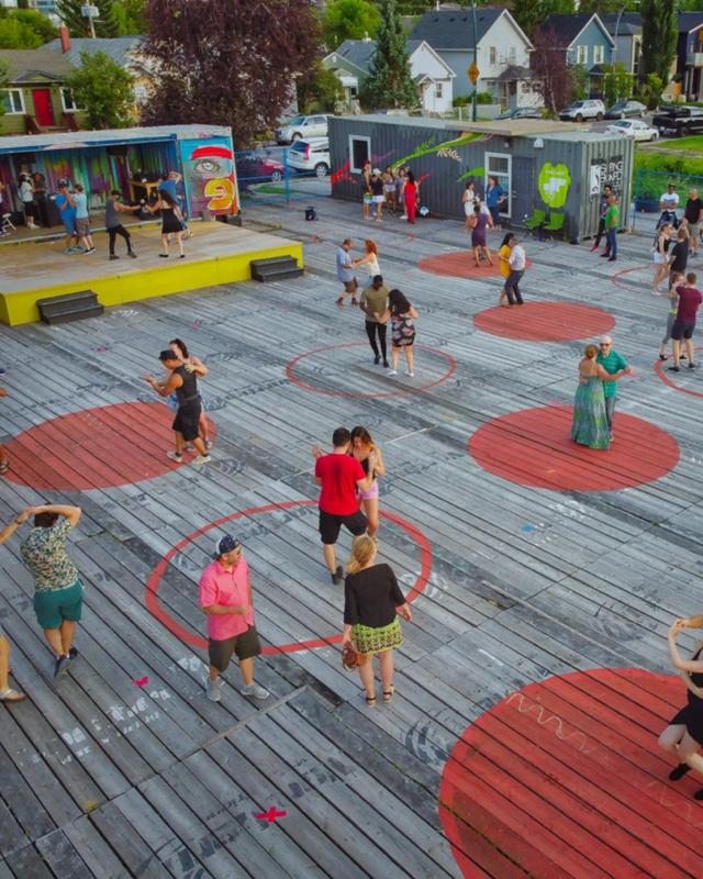 People dance in pairs on brightly-painted circles at an event
