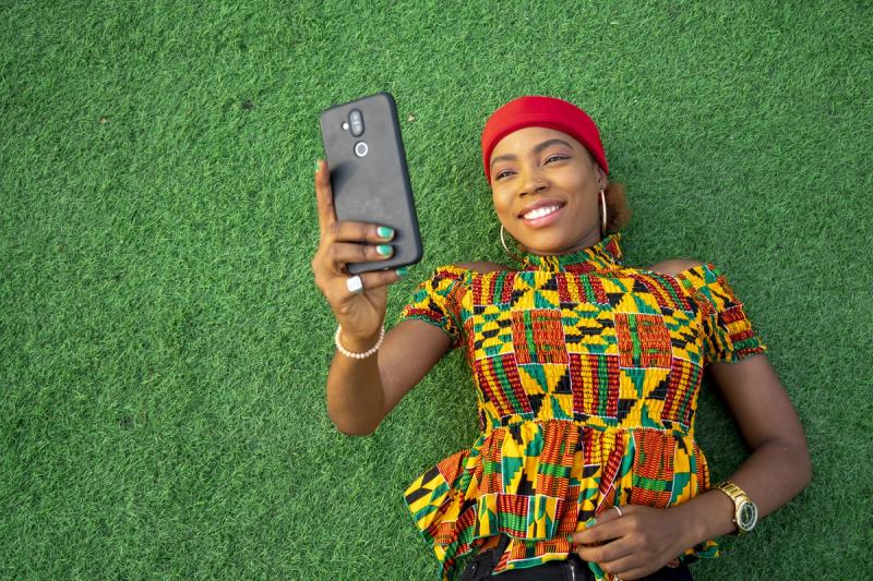 beautiful-young-black-female-laying-floor-park-using-her-mobile-phone.jpg