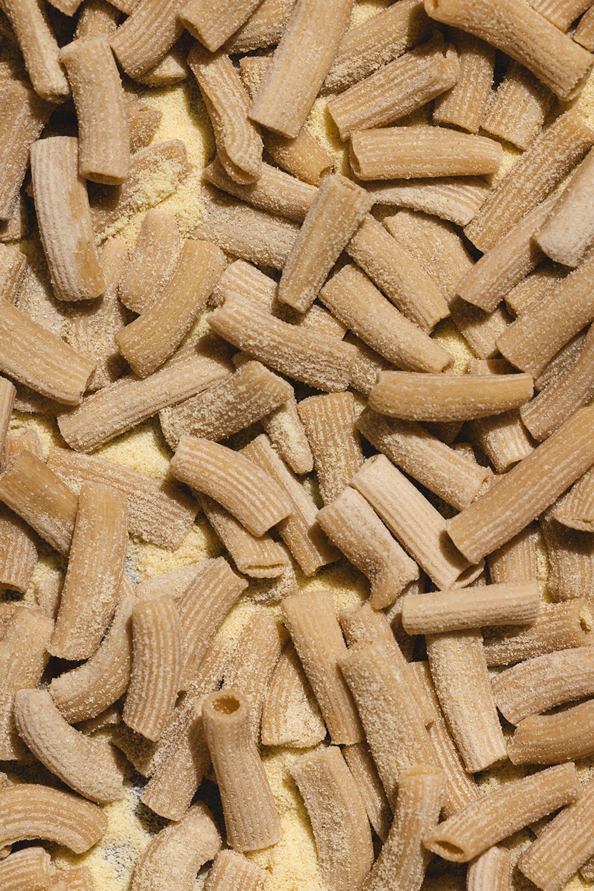 A sheet pan of hand-rolled rigatoni dusted with semolina flour
