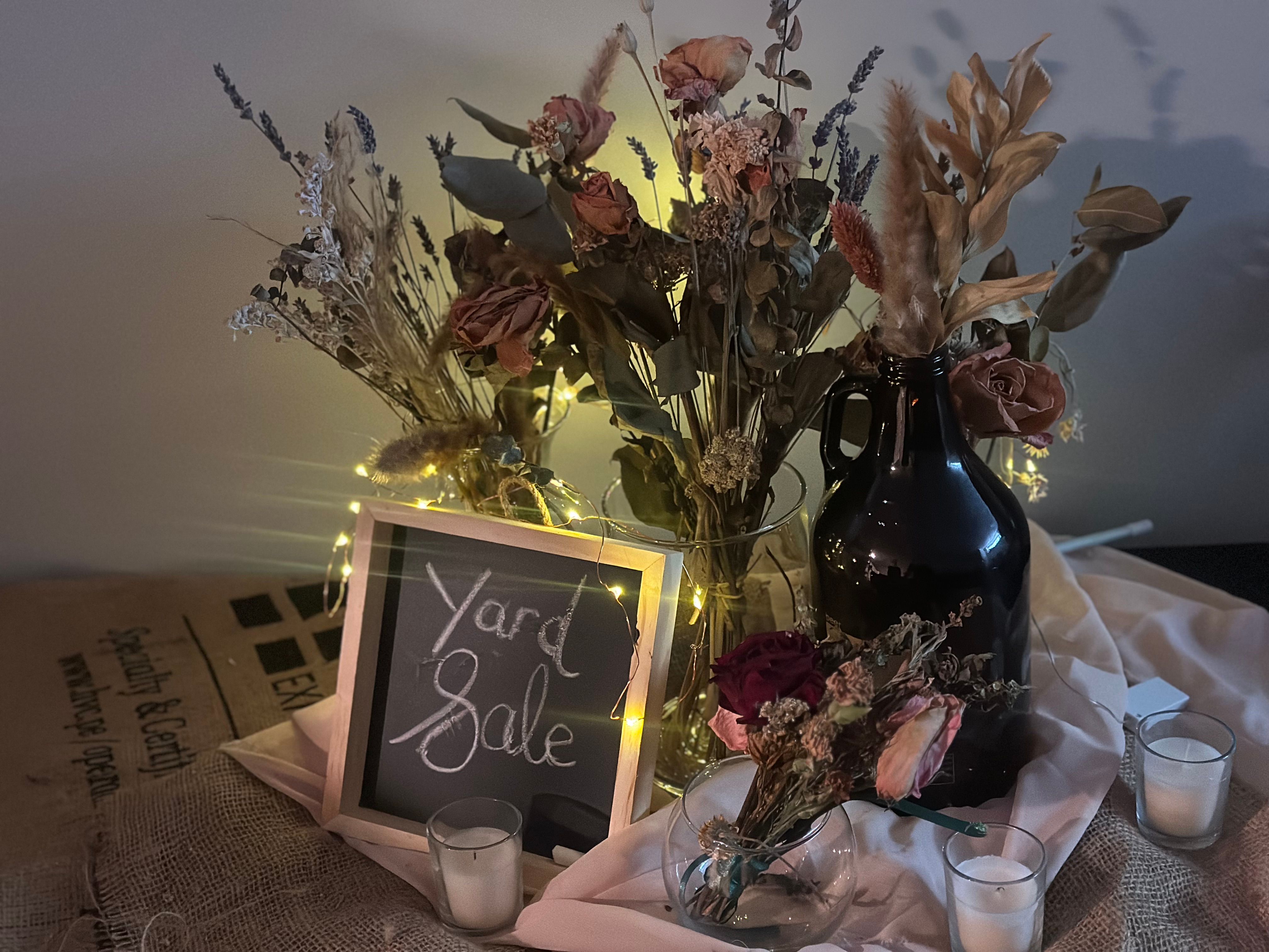 The dried-flower vase vignette on burlap, lit with fairy lights and votive candles.