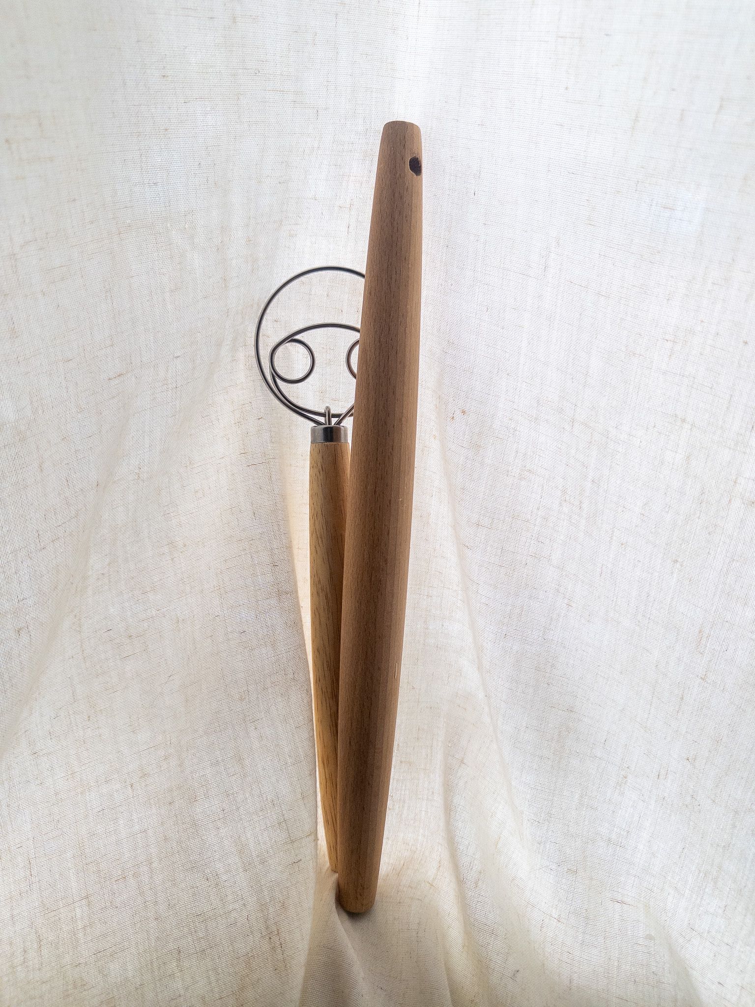 A wooden Danish dough whisk and a French tapered rolling pin.