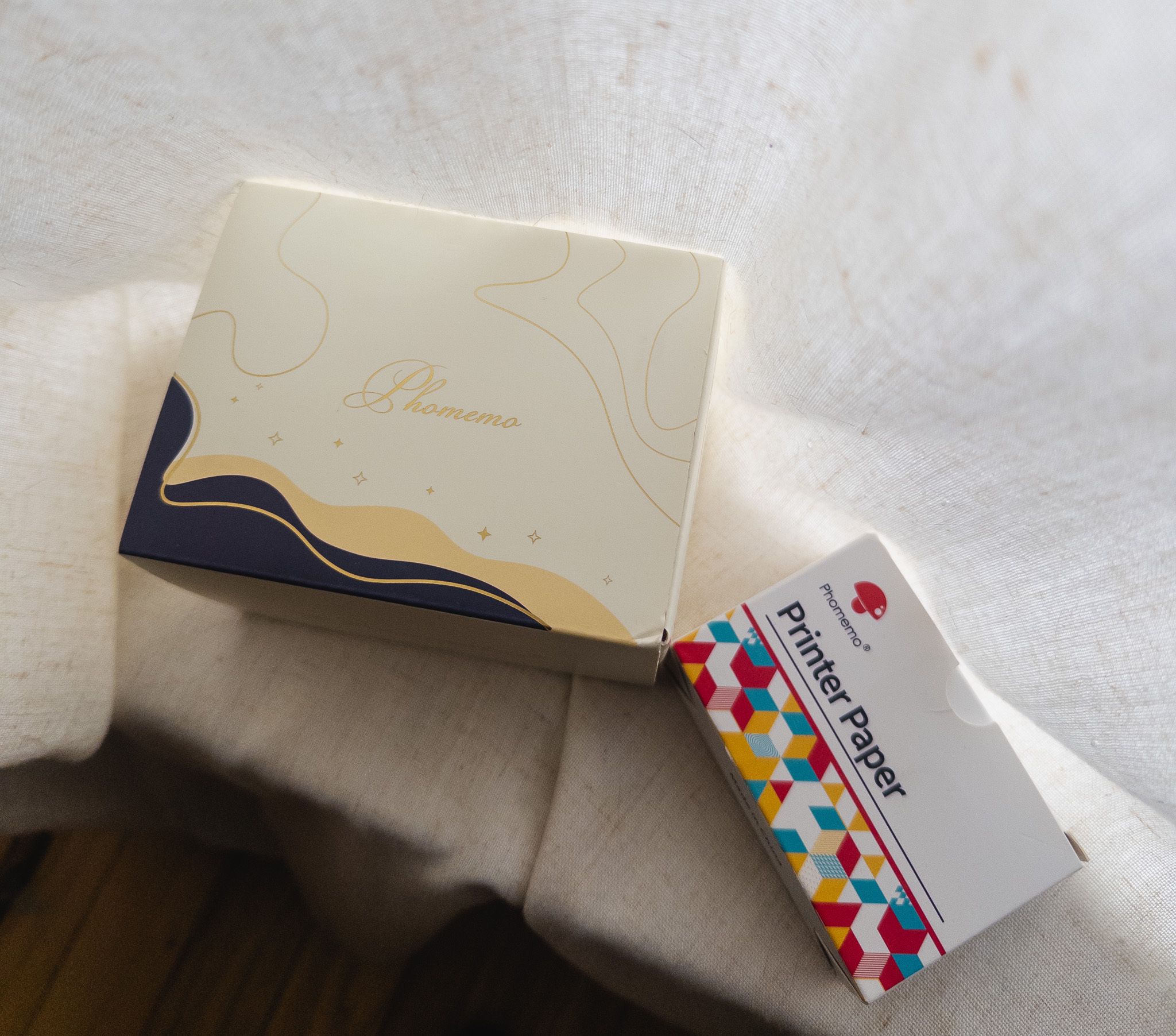 Phomemo thermal printer box with a box of printer paper.