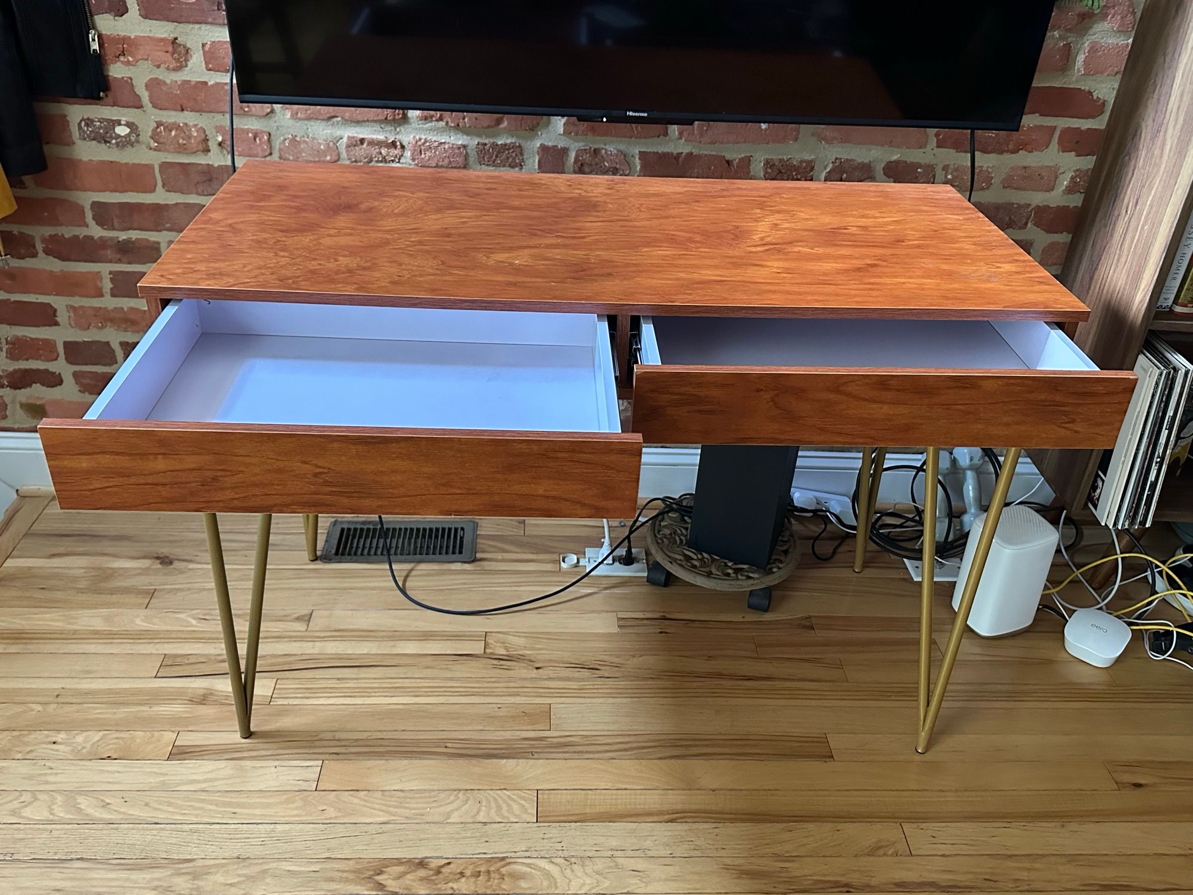 Midcentury-style wood desk with brass hairpin legs and two drawers.