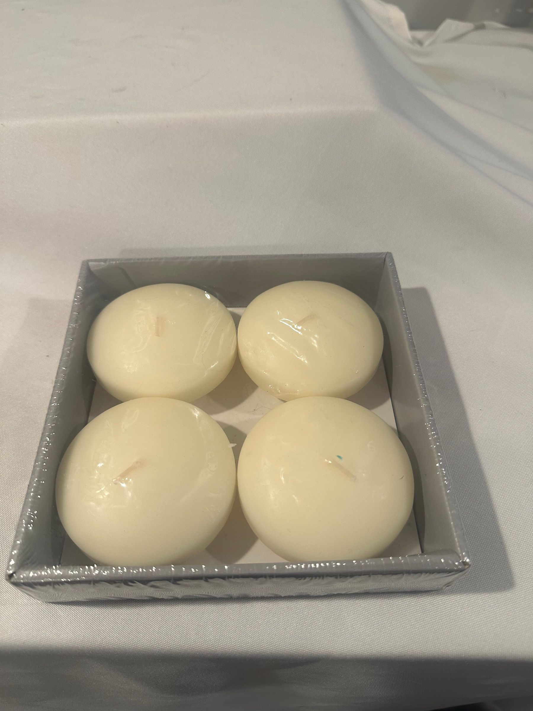 Four cream floating candles in a box.