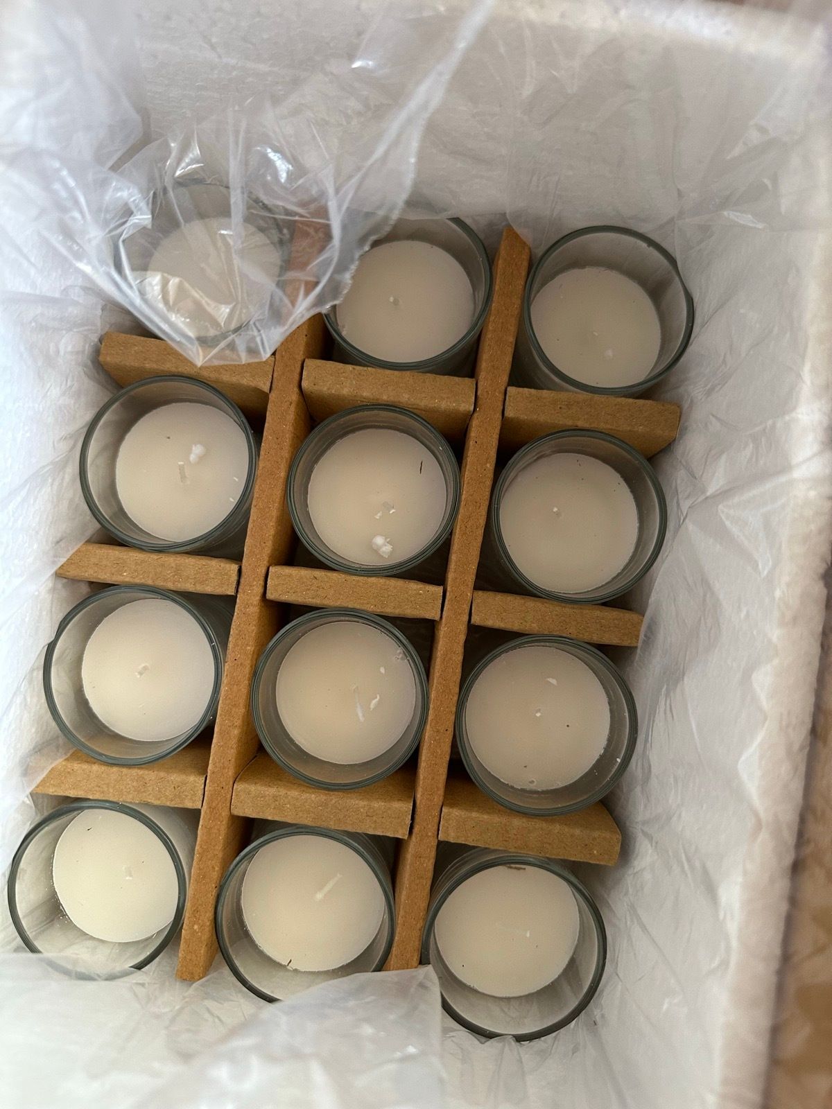 A box of Hosley clear glass votive candles.