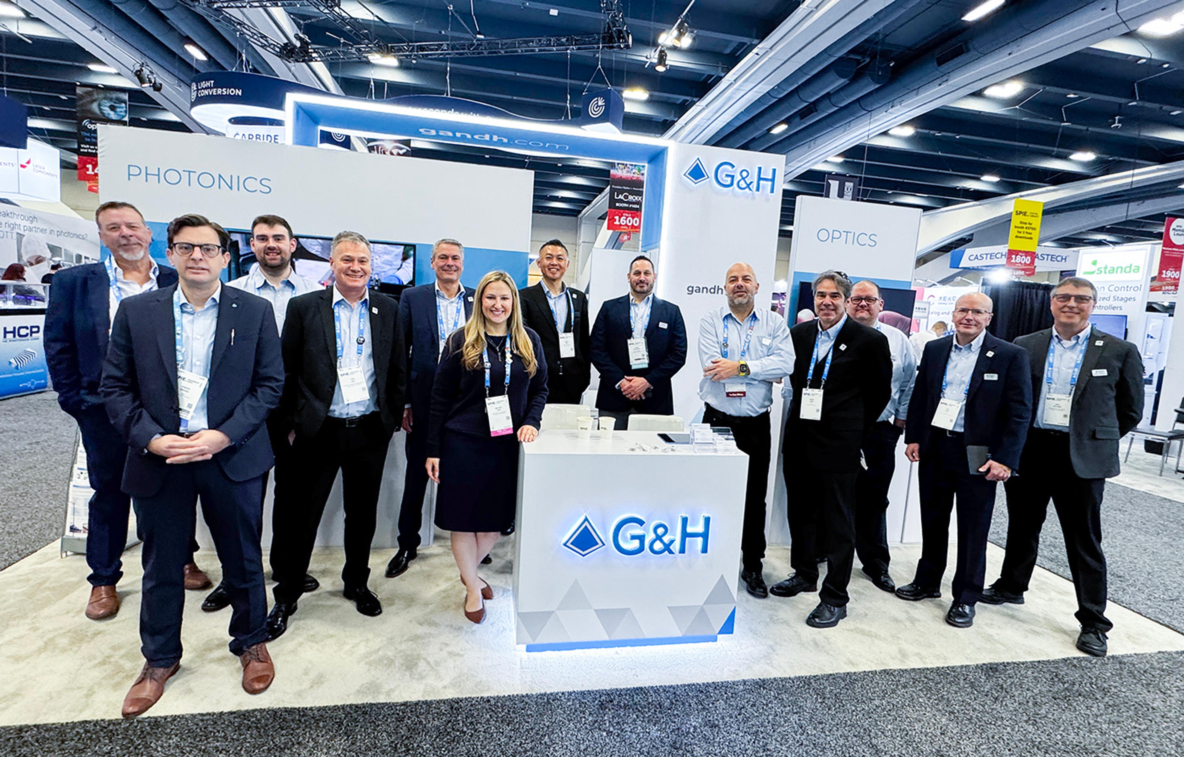 G&H team gathered at the company’s exhibition stand at Photonics West 2026, with illuminated G&H branding and photonics and optics displays.