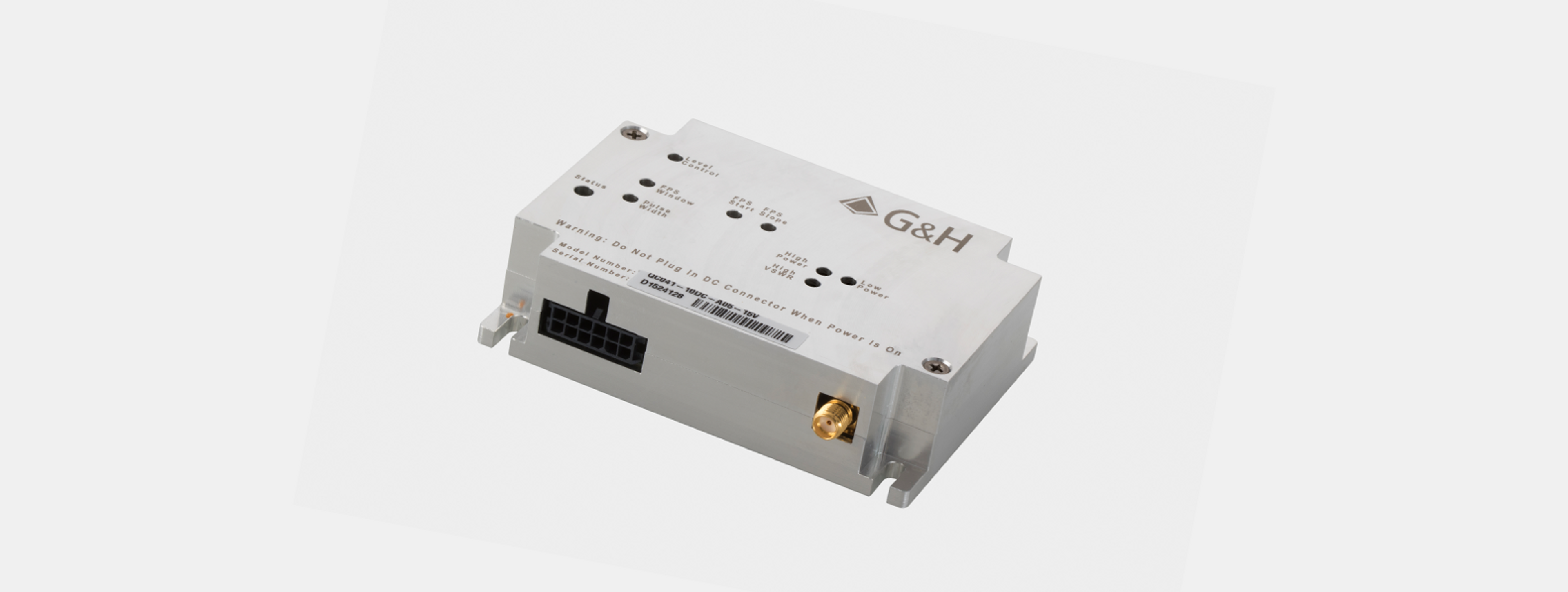 Compact low power RF AOM and AOQS driver product image - A compact silver rectangular G&H device labeled with model and serial number, designed for optical control or modulation. The unit features status indicators, control labels, and connection ports including a DC input and an RF output port. The warning text on the front panel reads "Do Not Plug in DC Connector When Power Is On," indicating its use in sensitive electronic or photonic systems.