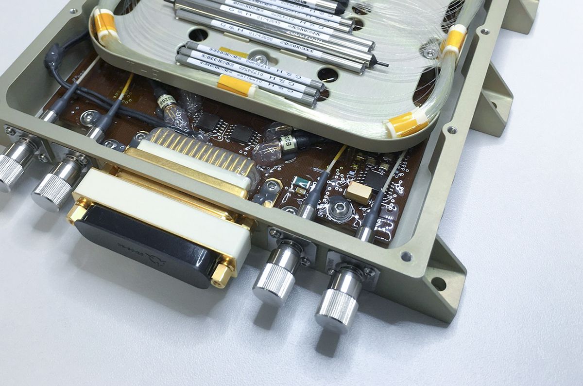 Internal view of a G&H custom OEM fiber optic module showing coiled optical fibers, precision components, electronic circuitry and multiple optical connectors within a rugged enclosure.