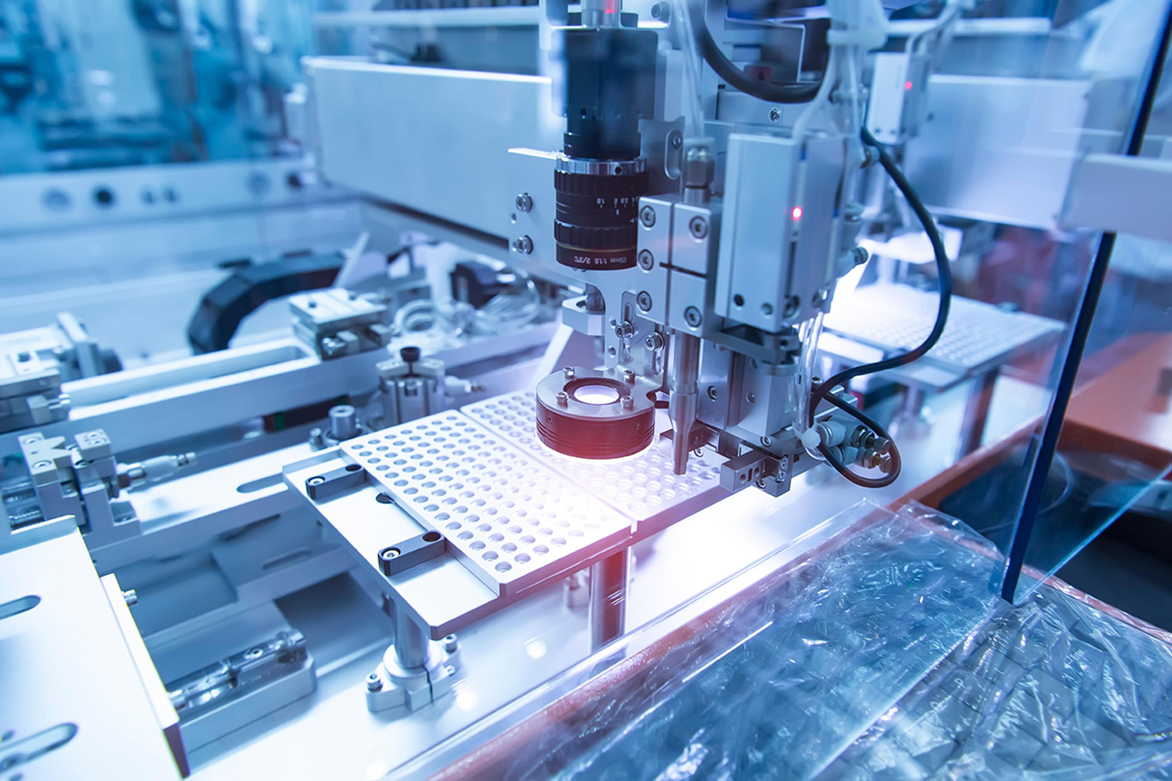 Laser-based semiconductor processing system - Close-up view of an automated machine in a cleanroom environment performing semiconductor processing tasks with precision instruments and robotic arms