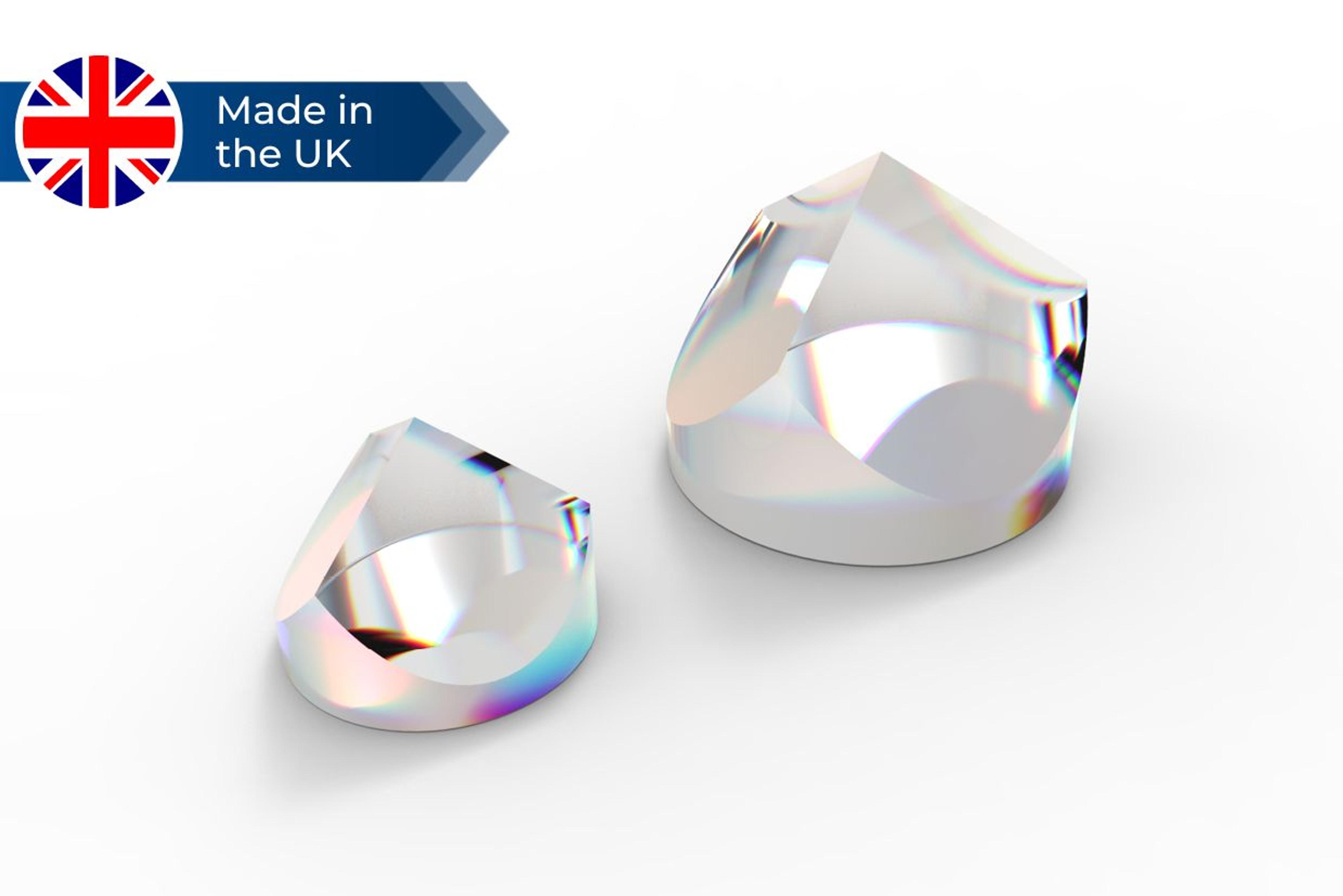 Two precision optical corner cube reflectors made of clear glass with prismatic facets and colorful light reflections, displayed on a white surface with a “Made in the UK” badge featuring a Union Jack flag.
