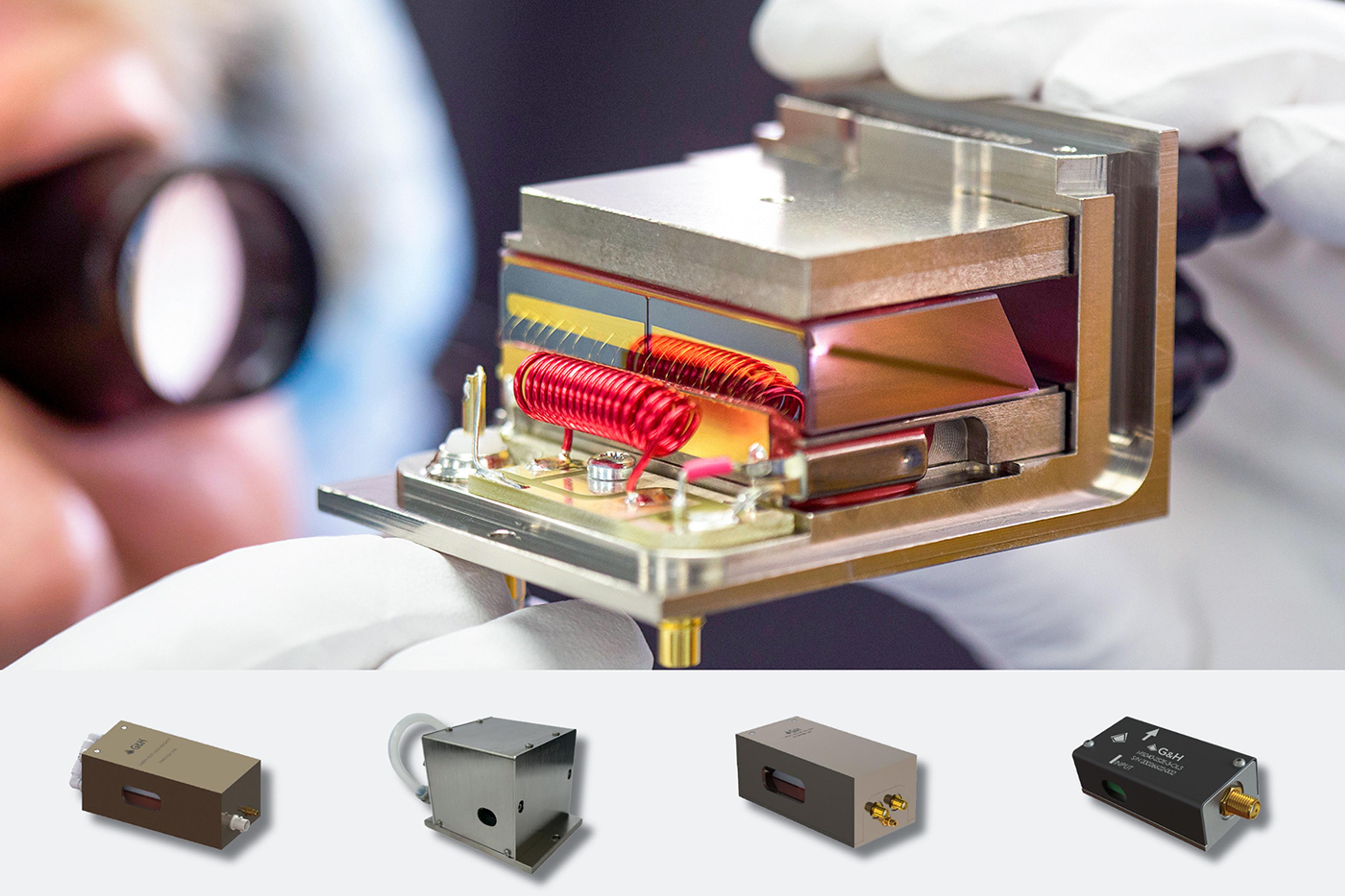 G&H acousto-optic device held by a technician wearing protective gloves, showing its precision crystal, electronic components and copper coils, with a selection of enclosed G&H acousto-optic modulators and related laser-control products displayed below.