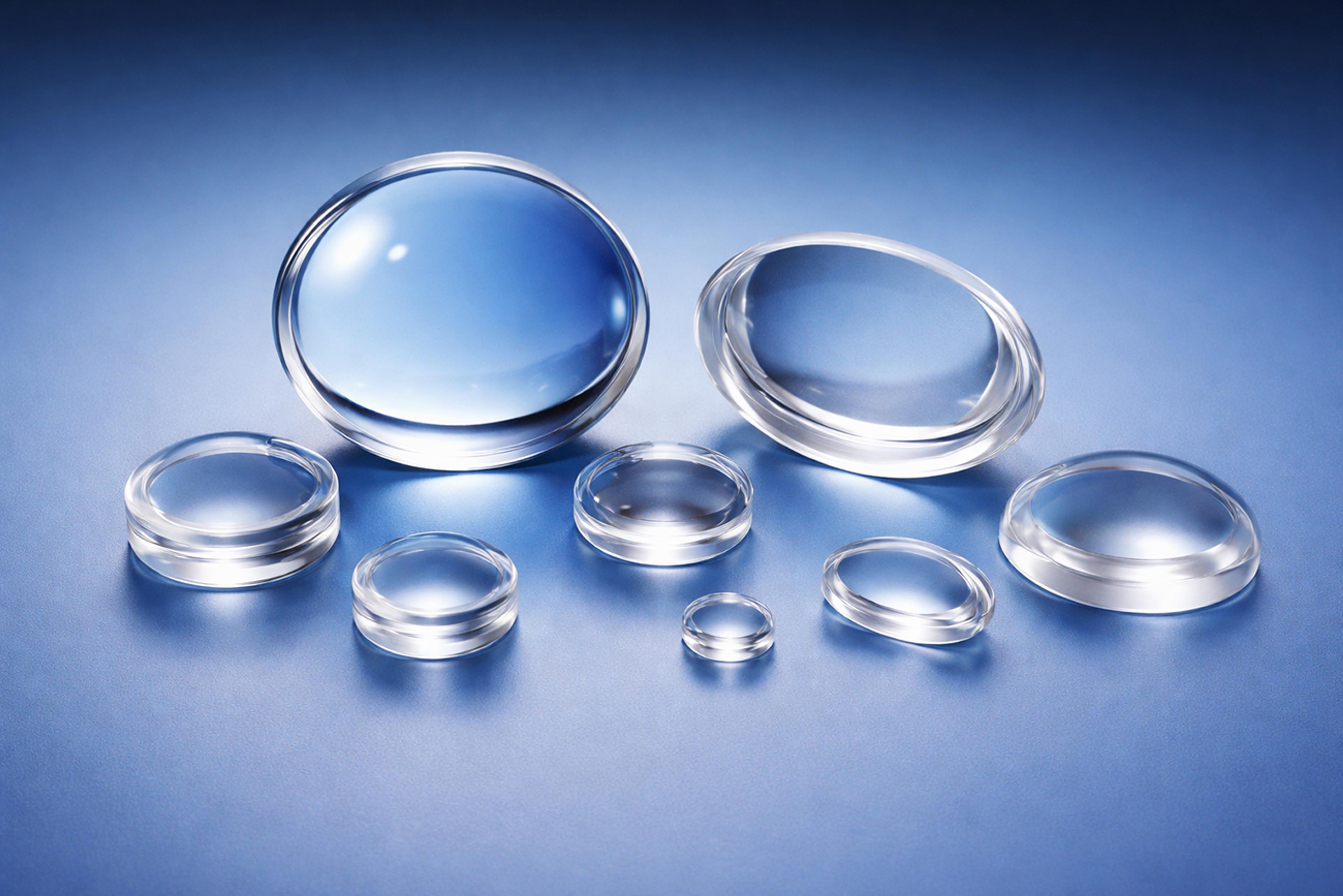 A selection of spherical polymer optic lenses on a blue graduated background