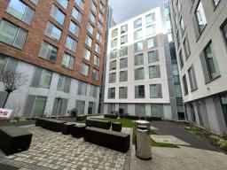 Modern student accommodation courtyard at IQ City Residence featuring outdoor seating, landscaped common area, and secure university housing in London, UK.