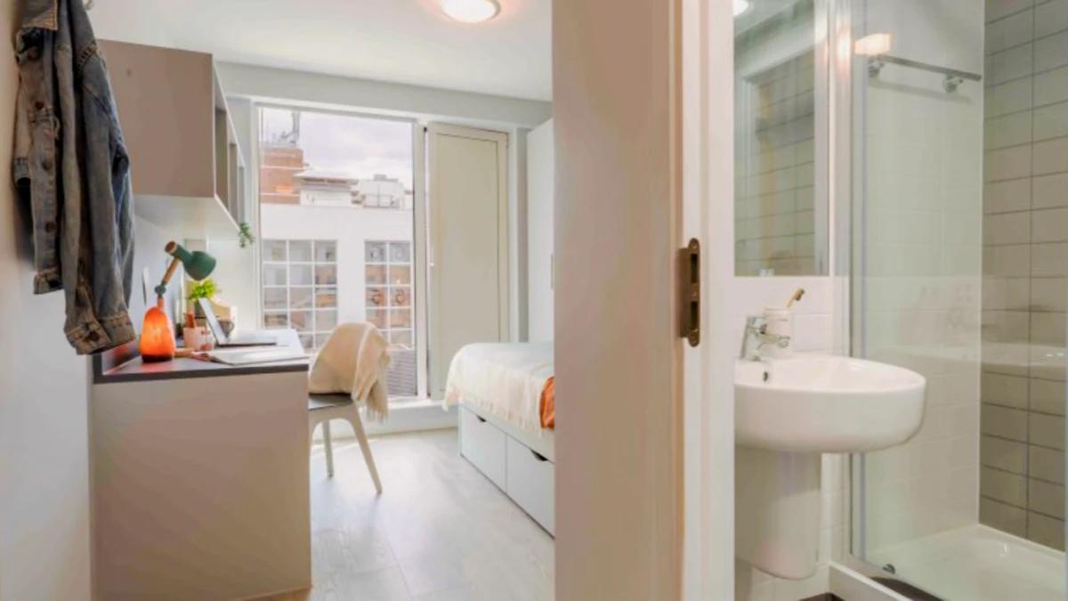 Fully furnished ensuite student room at IQ City Residence with study desk, private bathroom, natural daylight, and modern student accommodation in London, England.
