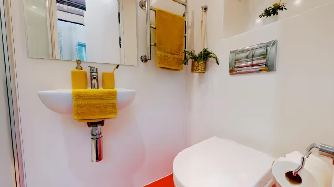Bright, modern ensuite bathroom featuring contemporary fittings and practical storage.