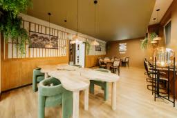 Stylish communal dining and study space with large tables, bar seating, pendant lighting, and contemporary décor.