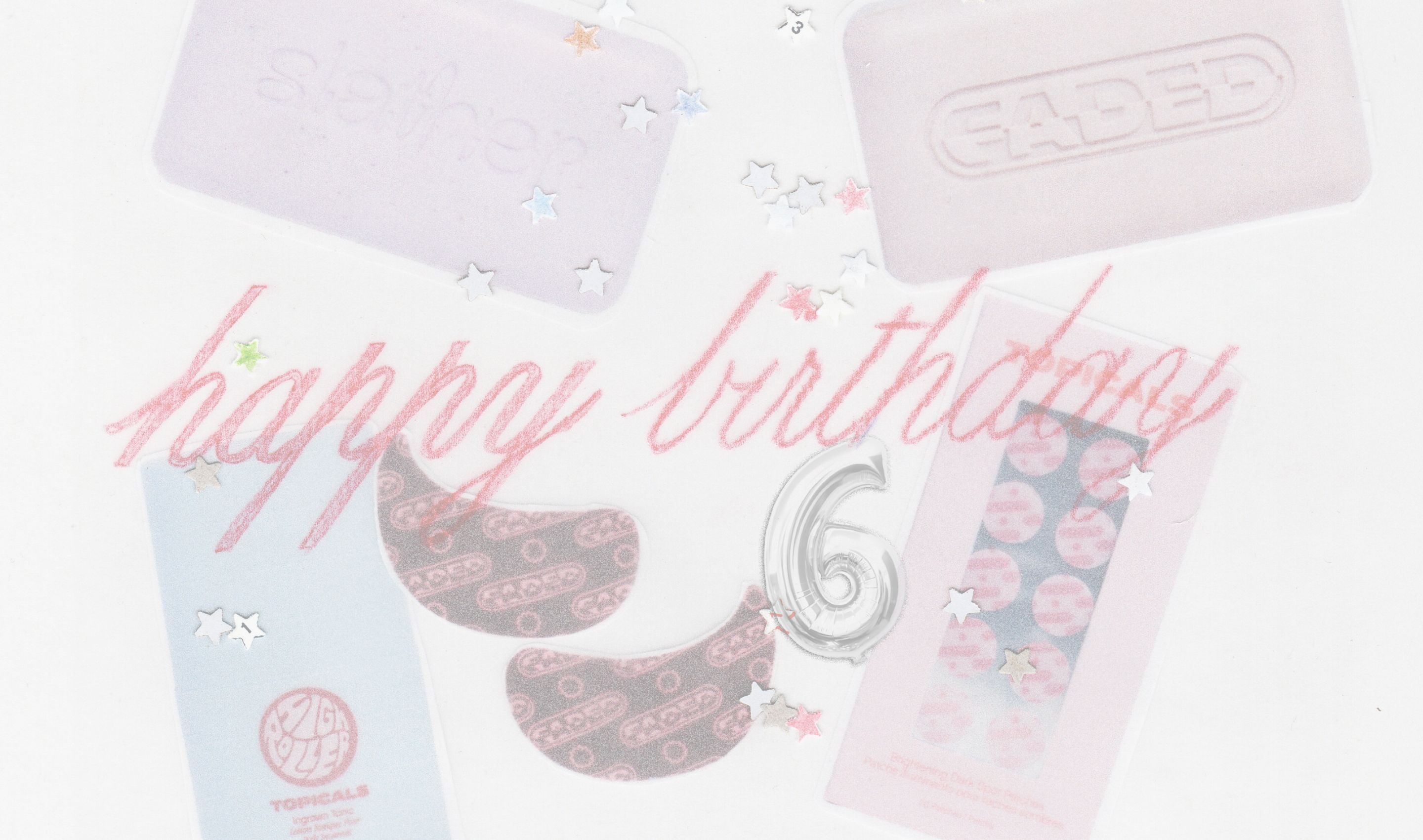 Flat lay of "Happy birthday" in red script with a number 6 balloon, pink bars, eye masks, and star confetti on a white surface.
