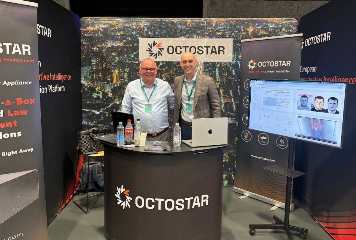 Octostar sales team at an Octostar exhibition booth with a live demo screen