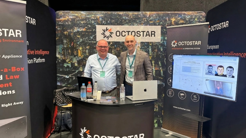 Octostar sales team at an Octostar exhibition booth with a live demo screen