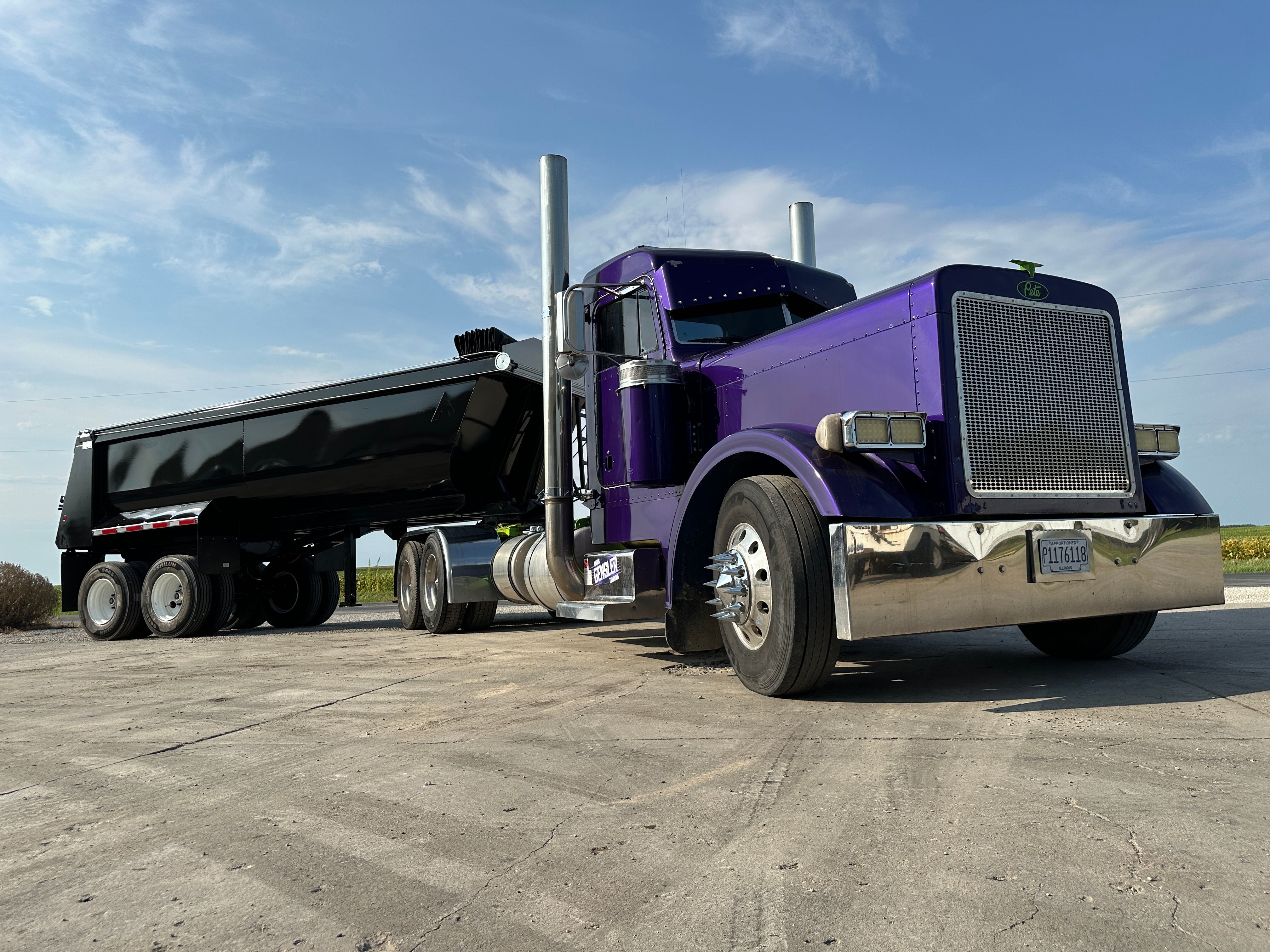Purple truck pulling on a black dump trailer