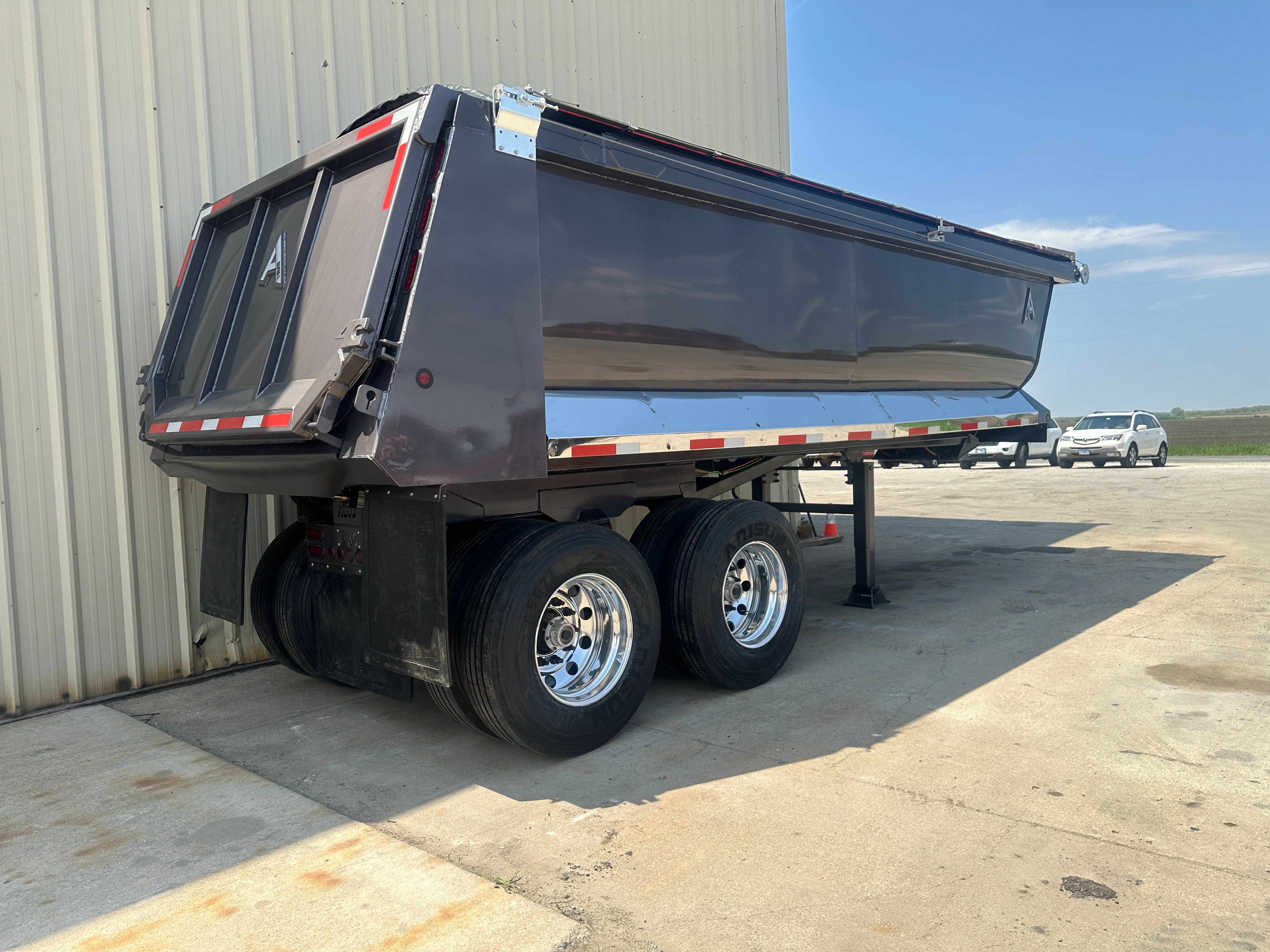 ALKO full frame dump trailer loading armor stone on a Cedar Rapids flood protection project