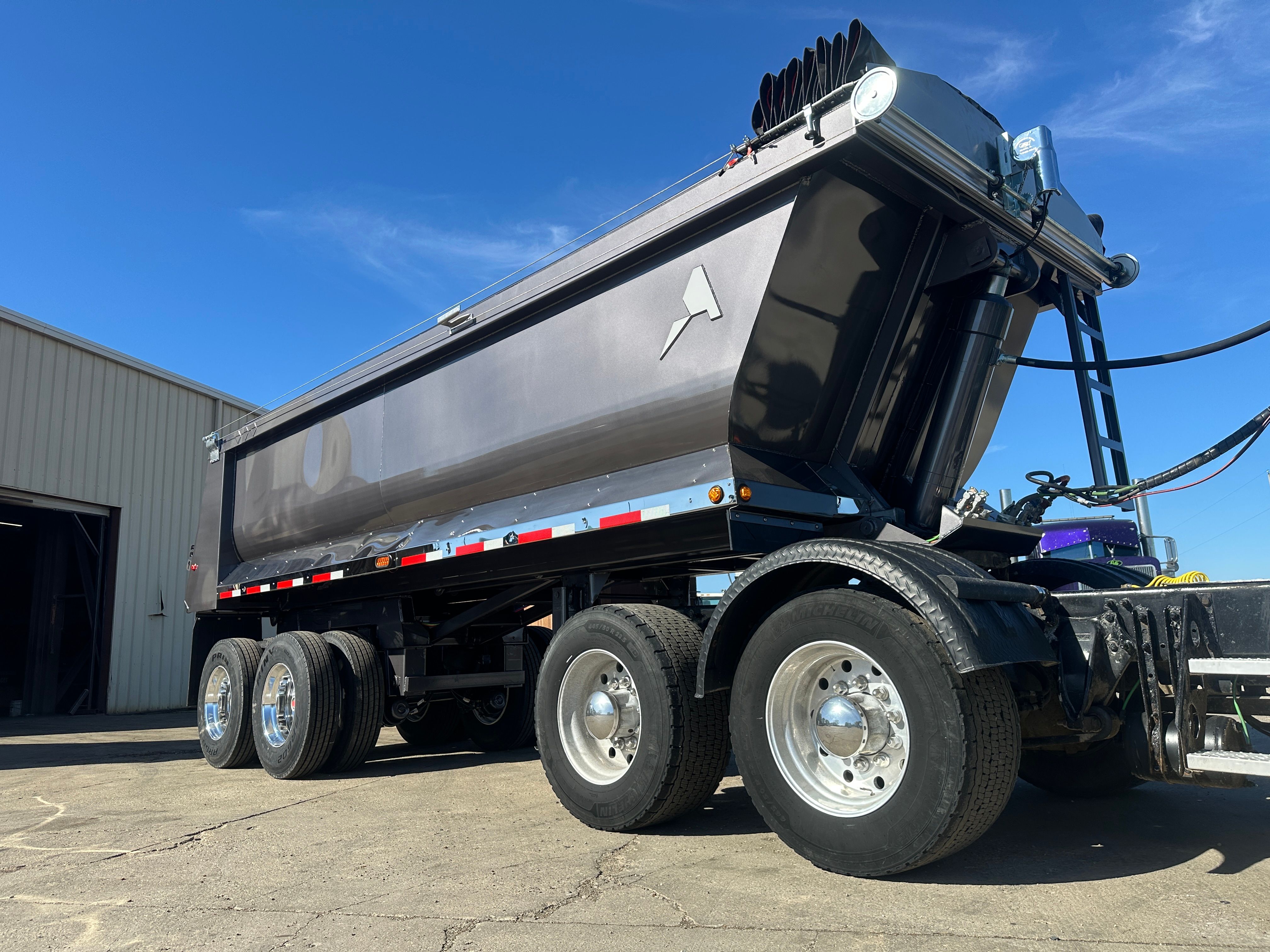 ALKO full frame dump trailer loading armor stone on a Cedar Rapids flood protection project