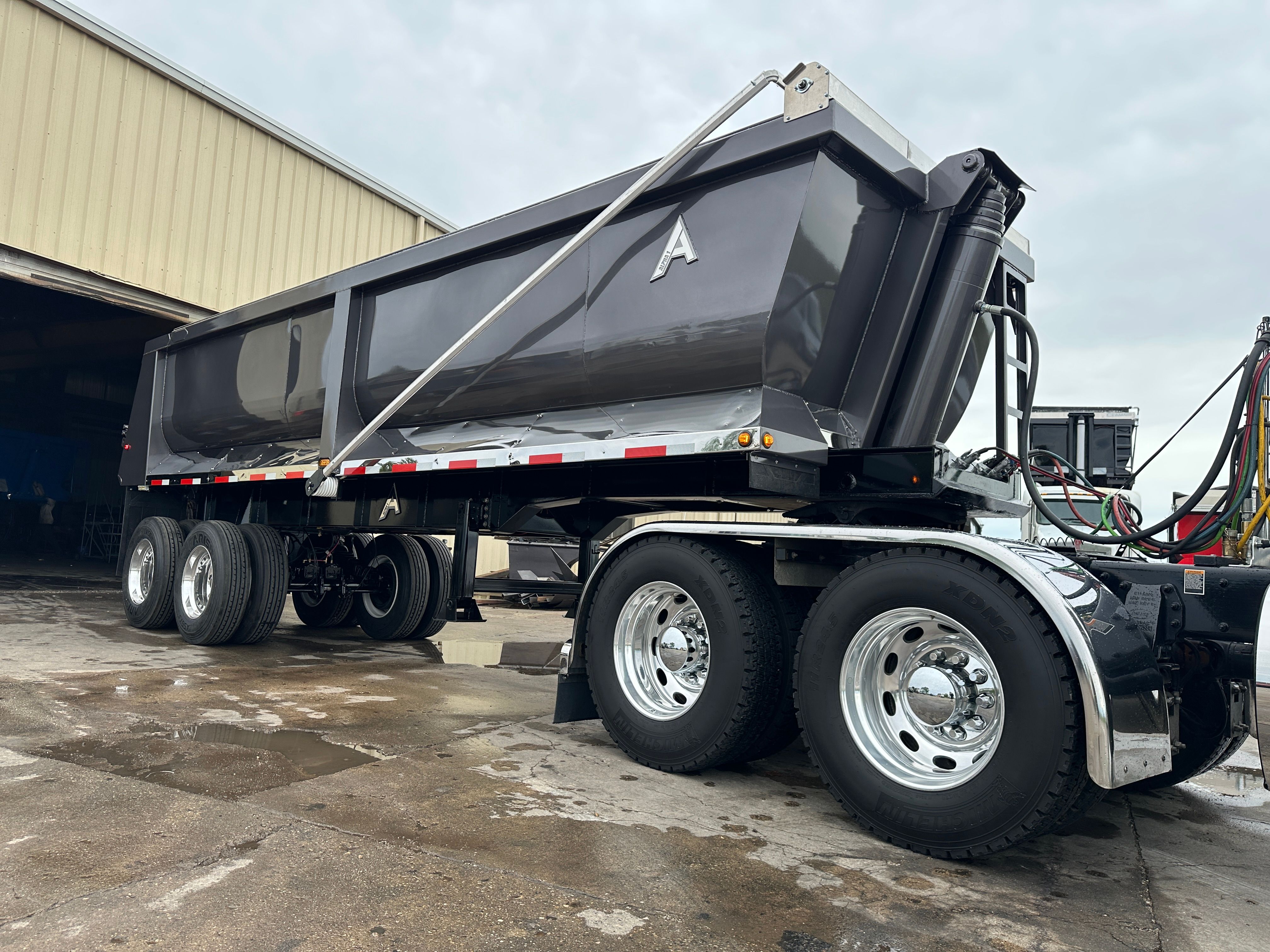 ALKO full frame dump trailer loading armor stone on a Cedar Rapids flood protection project