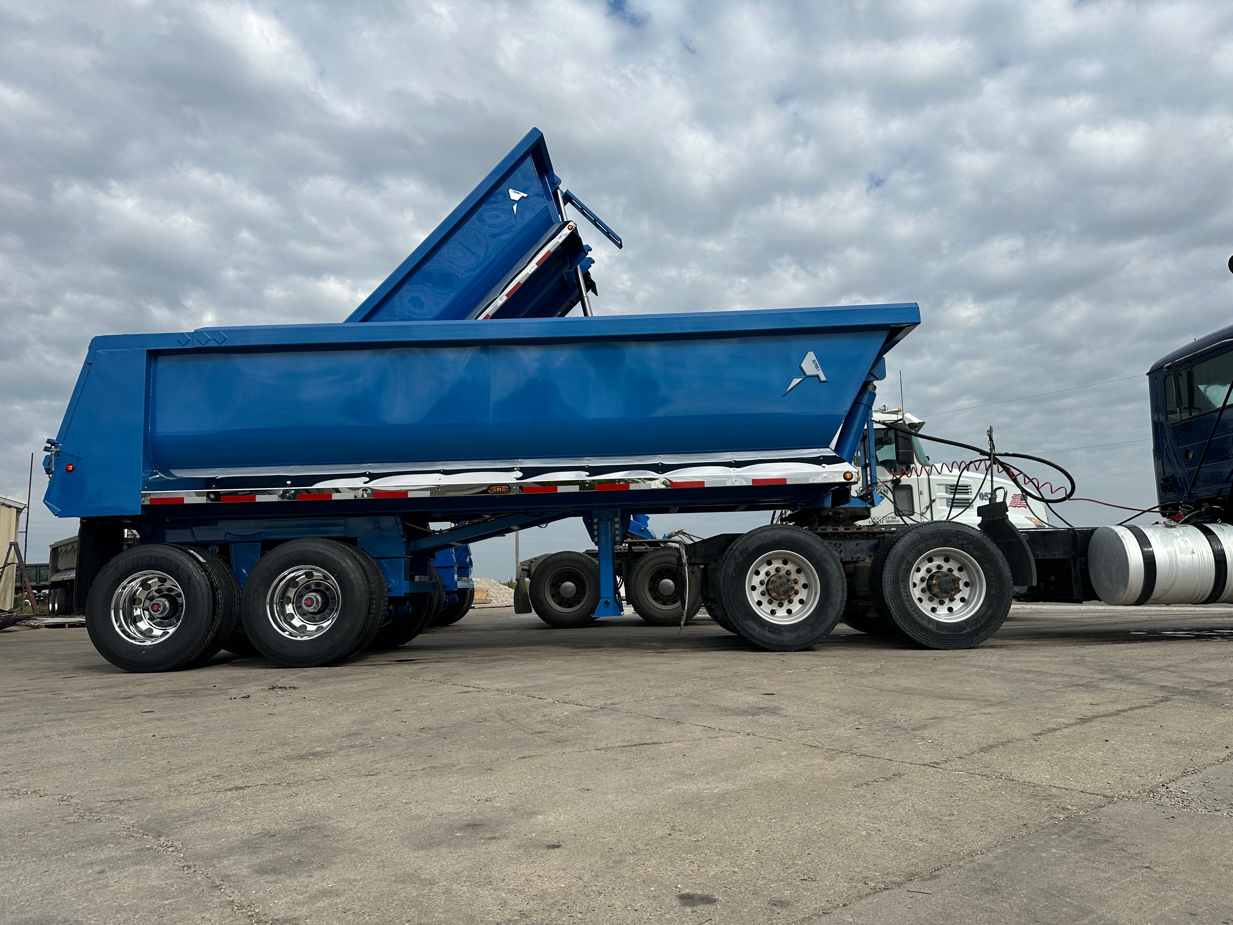 ALKO full frame dump trailer loading armor stone on a Cedar Rapids flood protection project