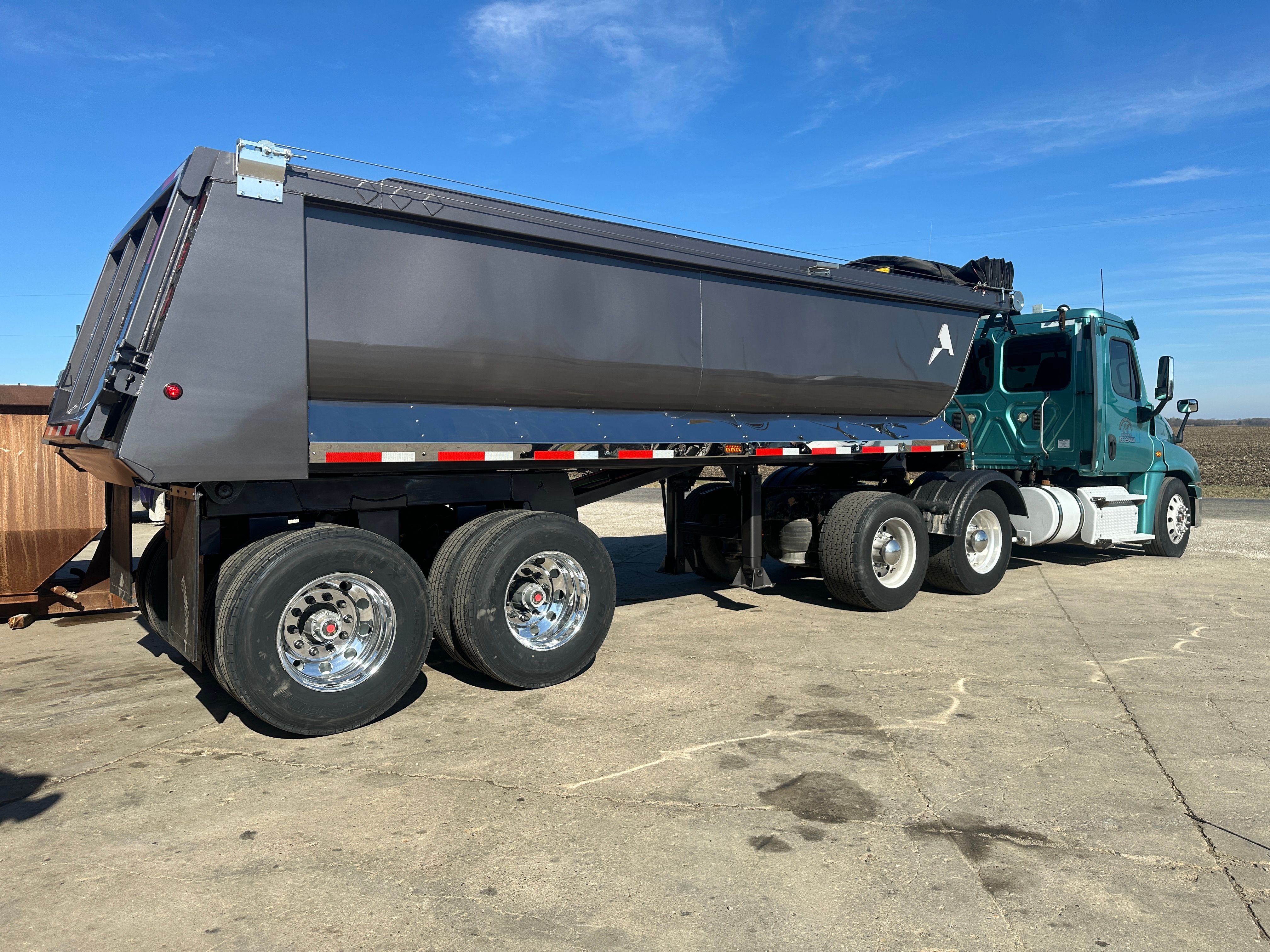 ALKO full frame dump trailer loading armor stone on a Cedar Rapids flood protection project