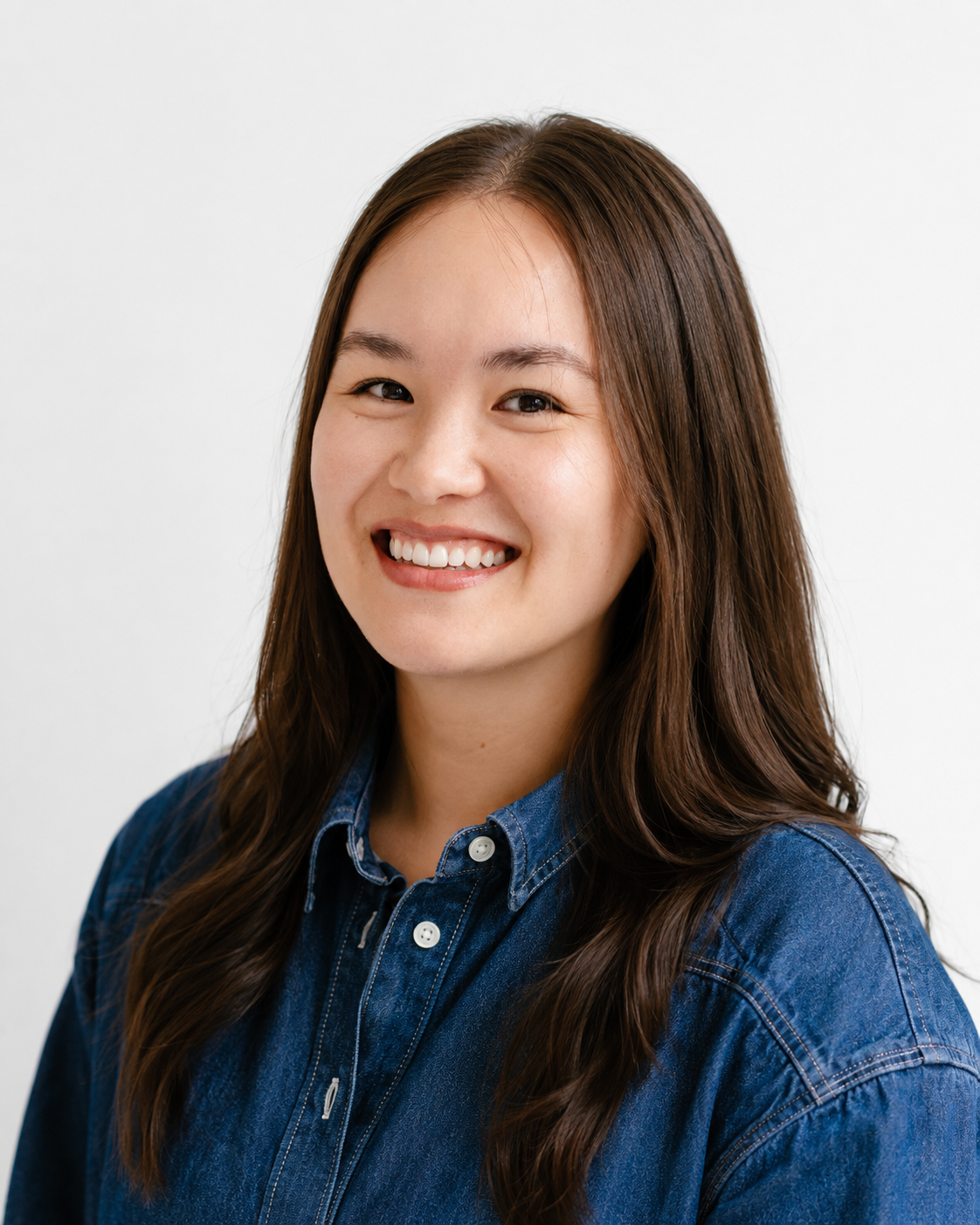 Sarah Dempsey smiling in a denim shirt.