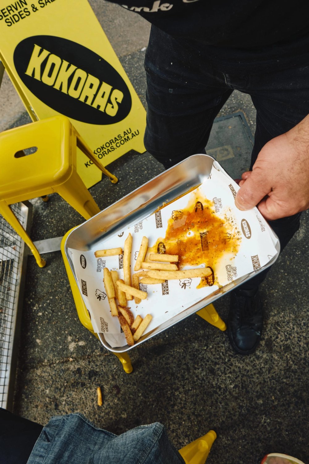 Chips and gravy in a steel tray outside Kokoras