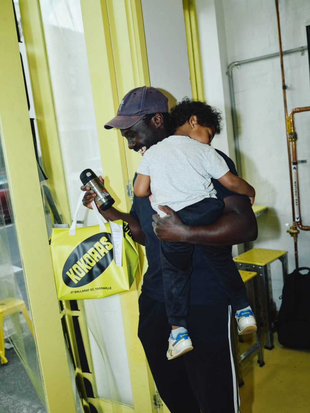 A customer carrying a child and a Kokoras bag