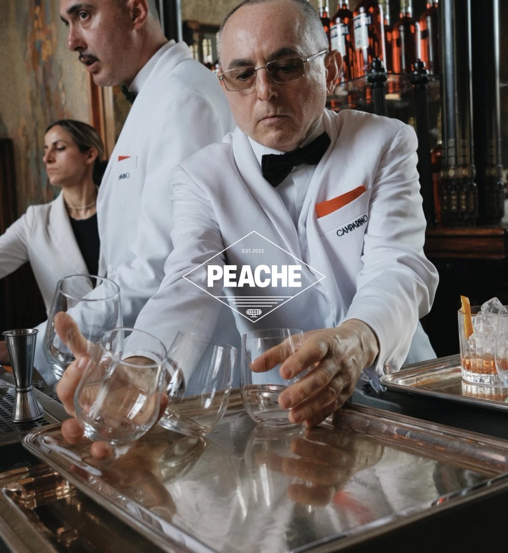 Bartenders in white jackets at Camparino with the Peache badge