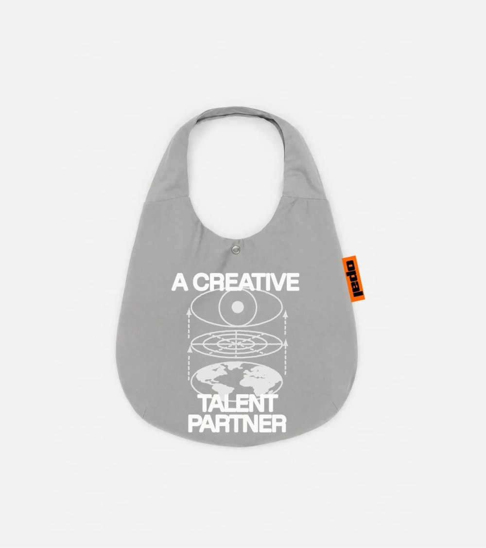 Grey Opal tote bag printed with "A creative talent partner" and a globe illustration