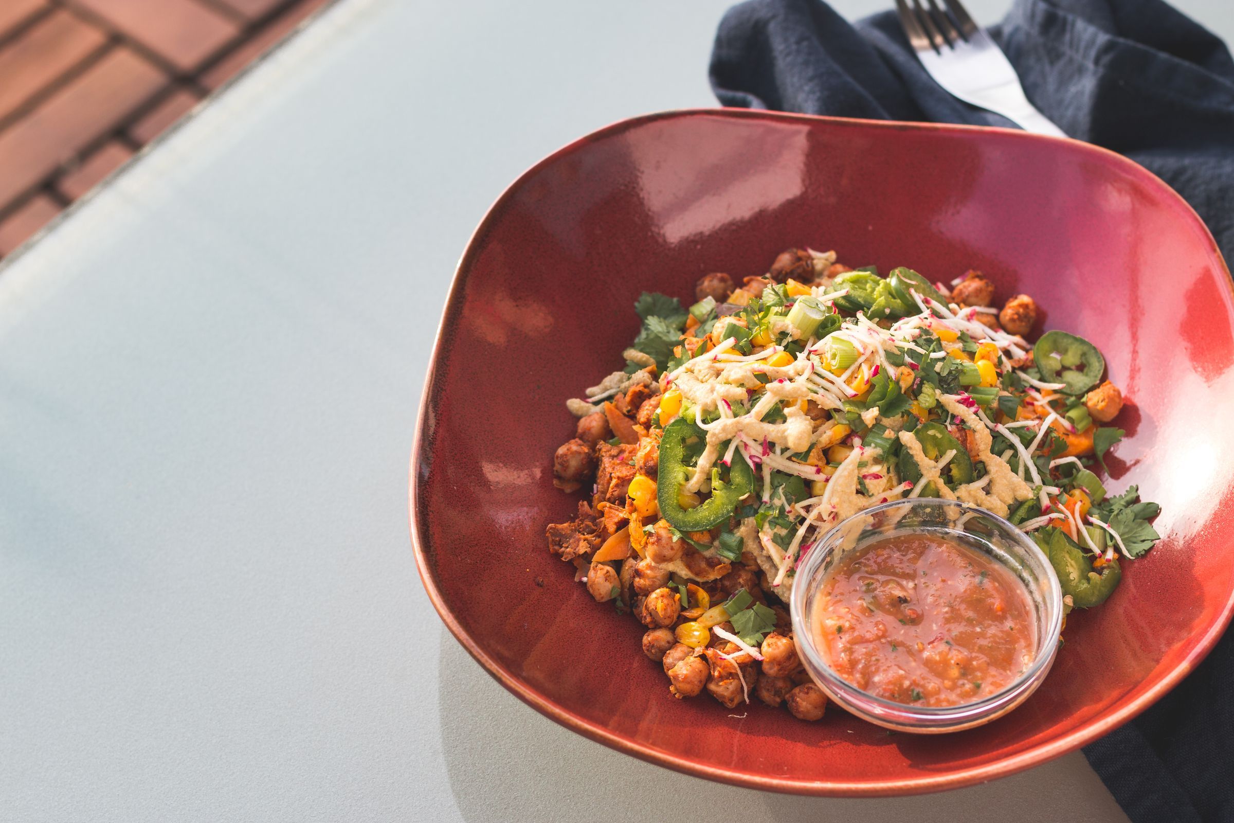 A chickpea salad in a red bowl.