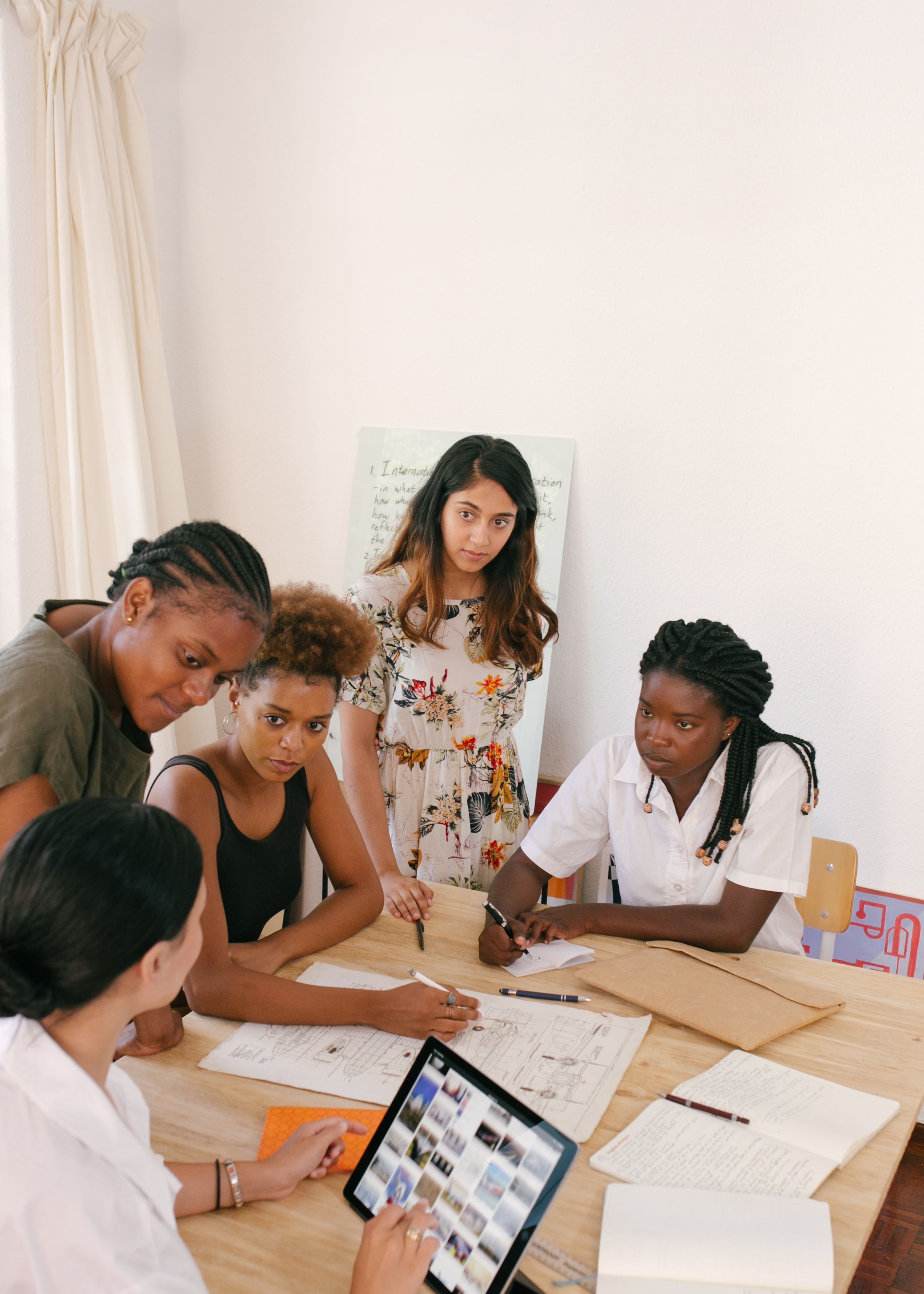 Women discussing work around a table.