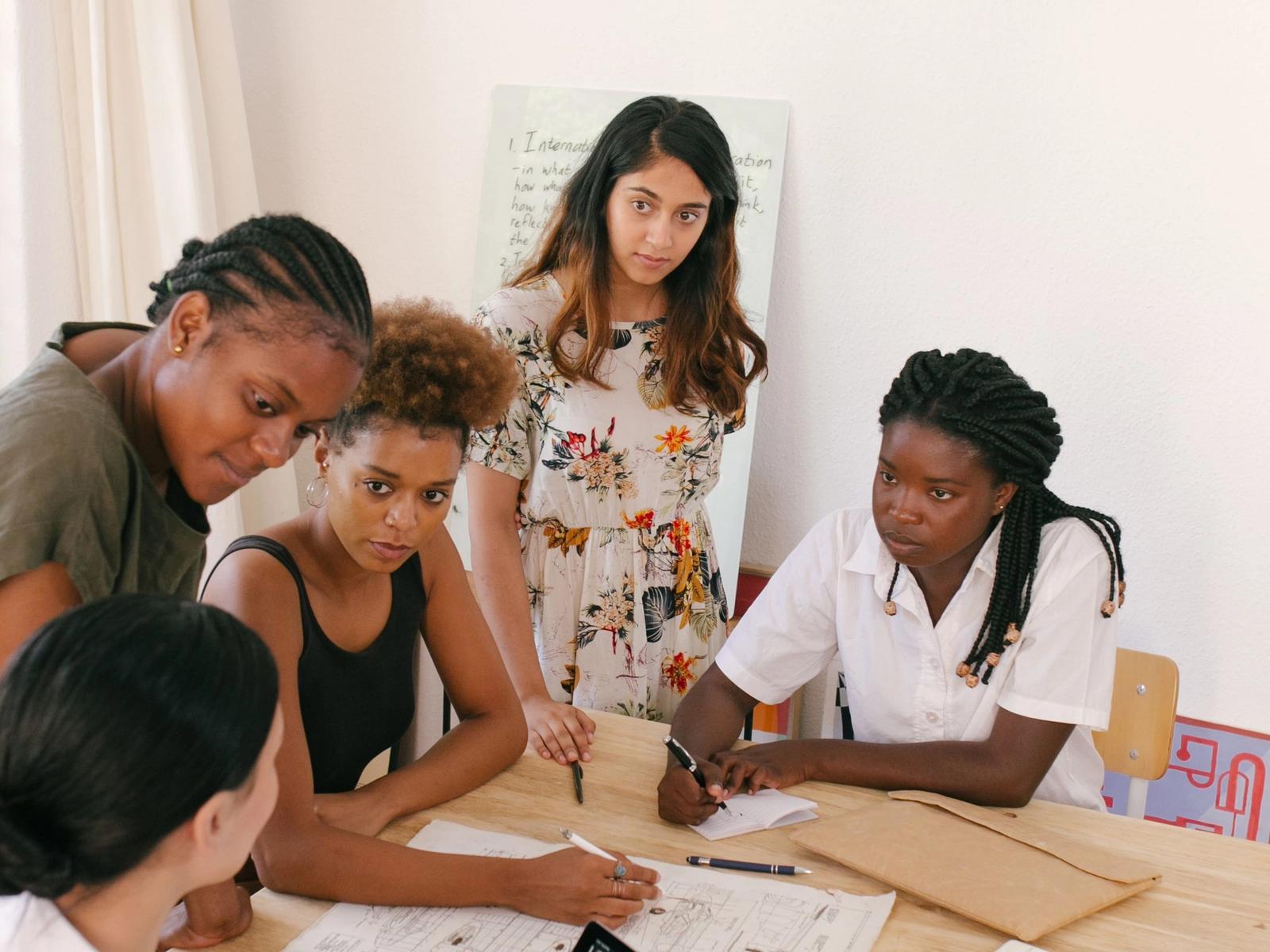 Women discussing work around a table.