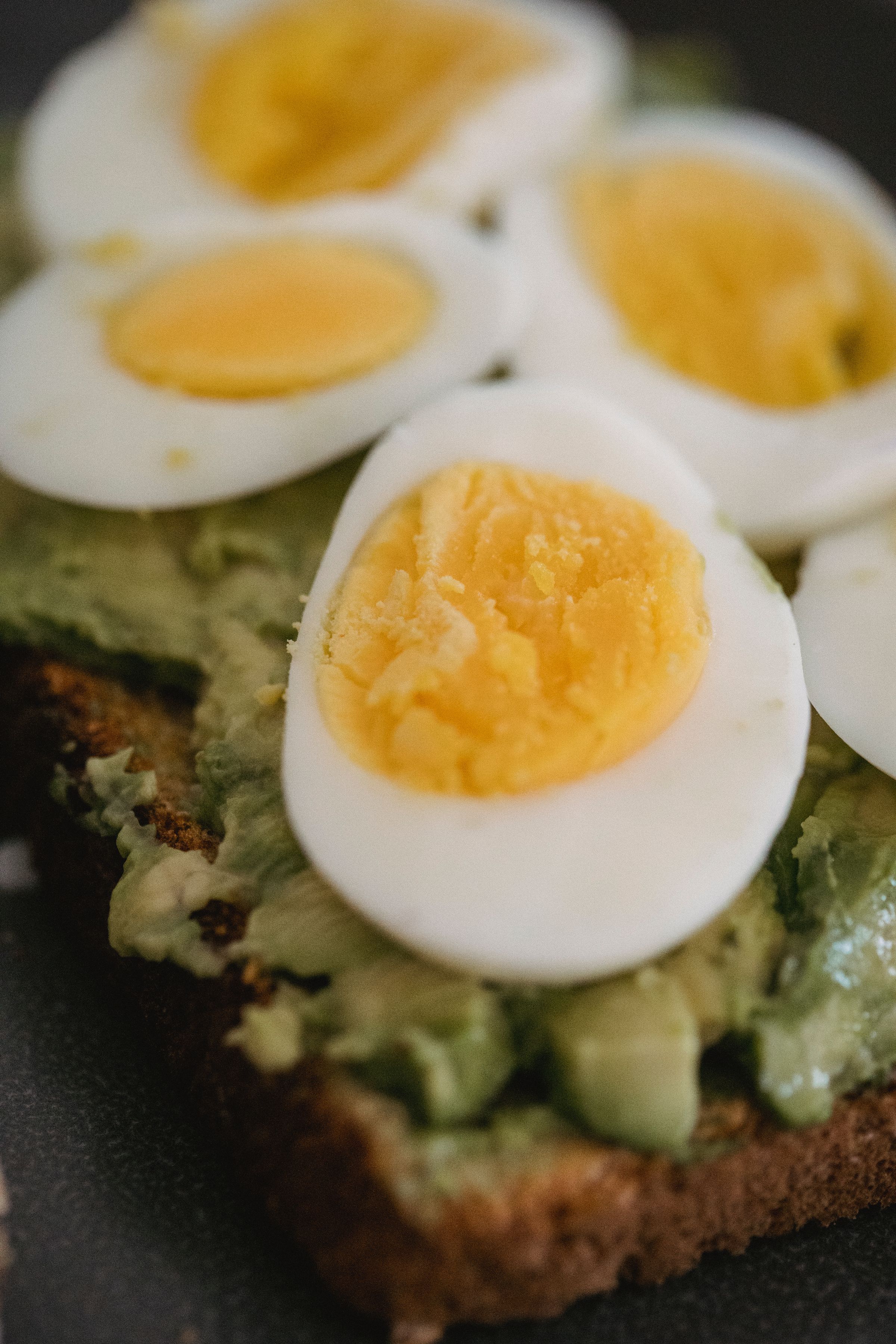 Toast topped with sliced avocado and egg.
