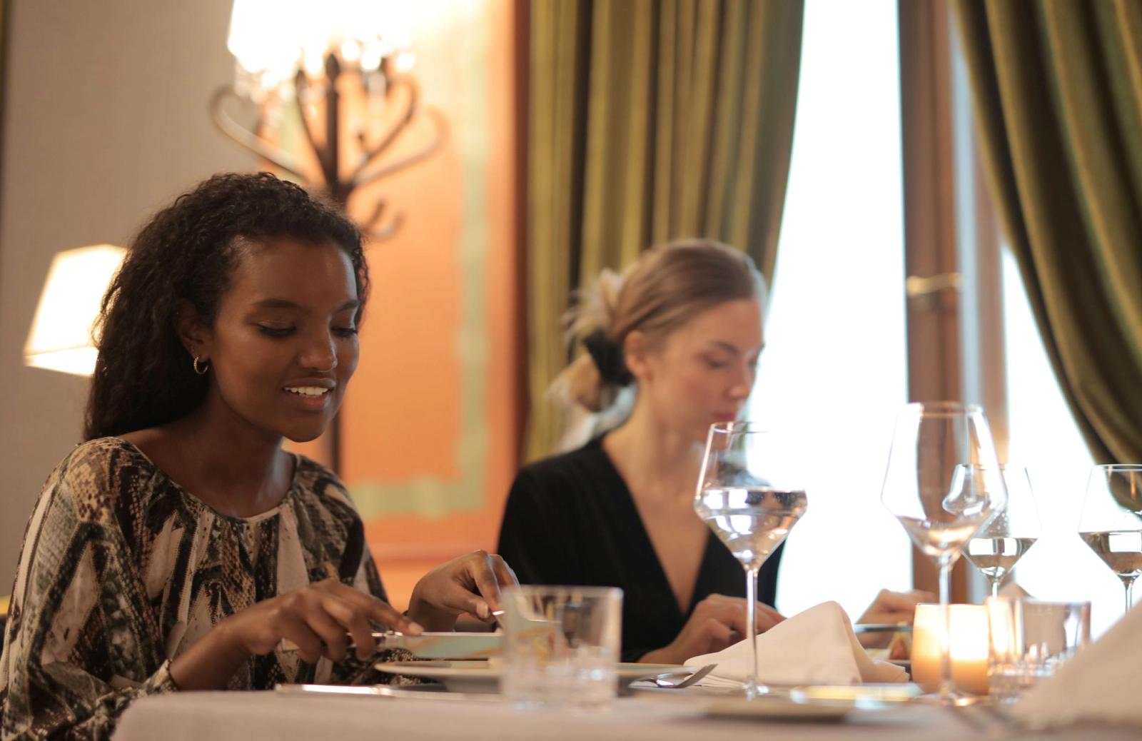 Two women sharing a meal at a restaurant table.