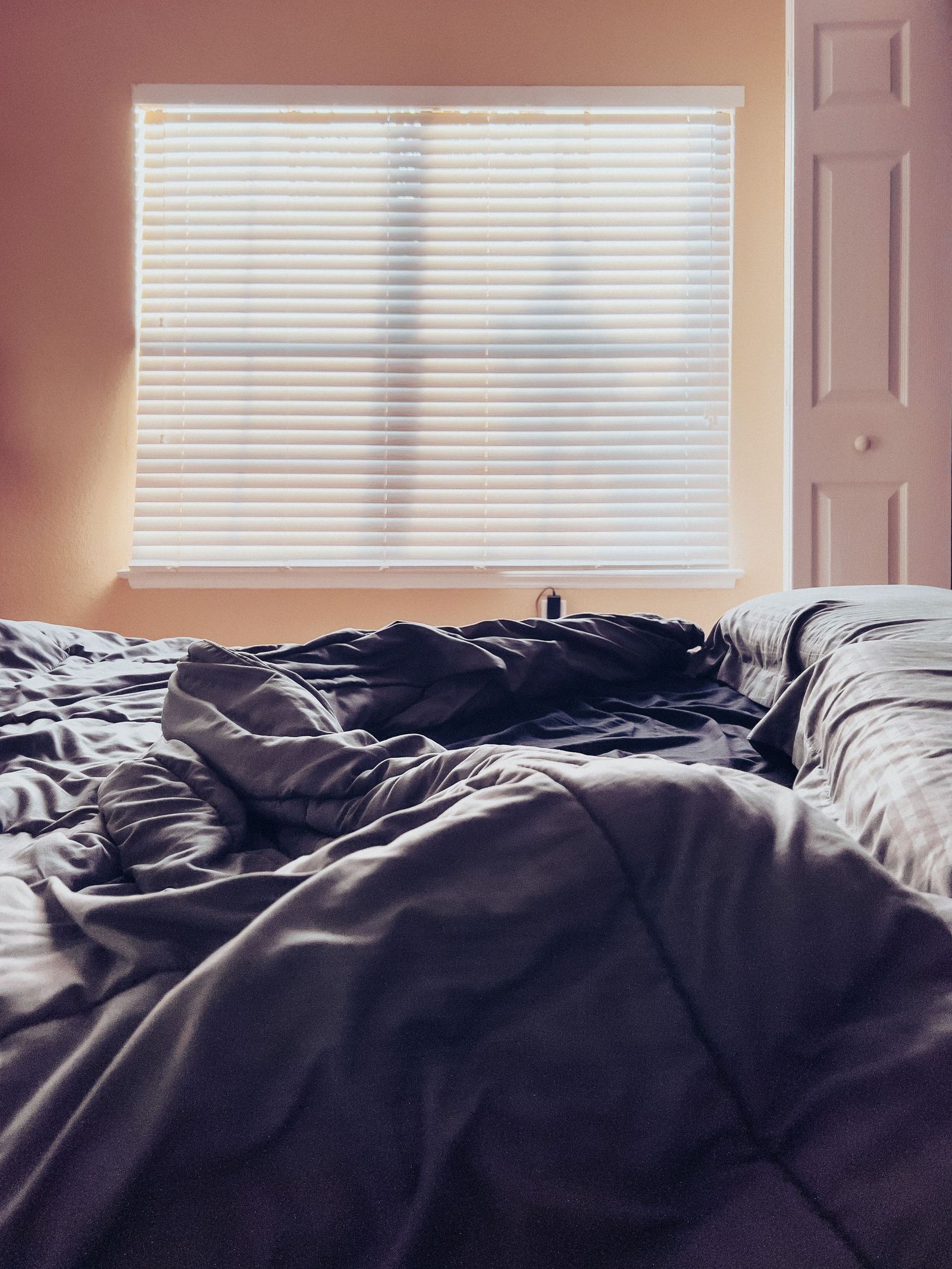 Dark bedding in a sunlit room.