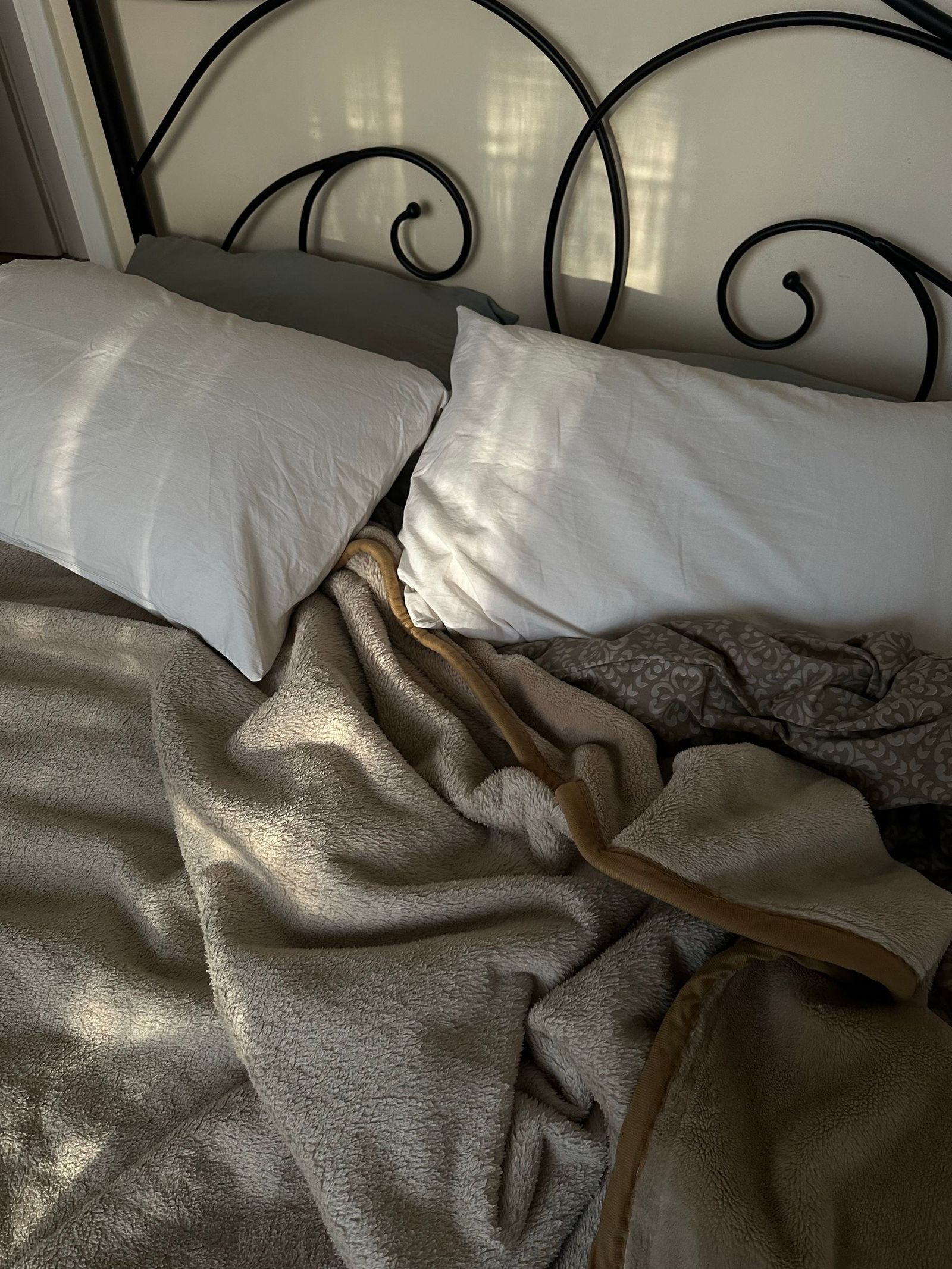 Pillows and blankets on an unmade bed.