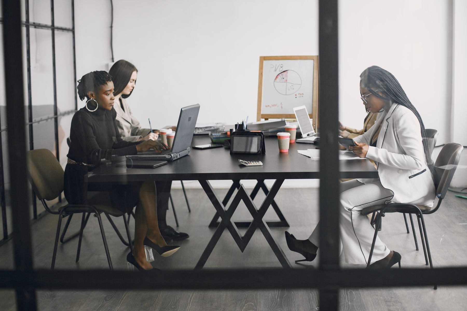 Women seated around an office meeting table.